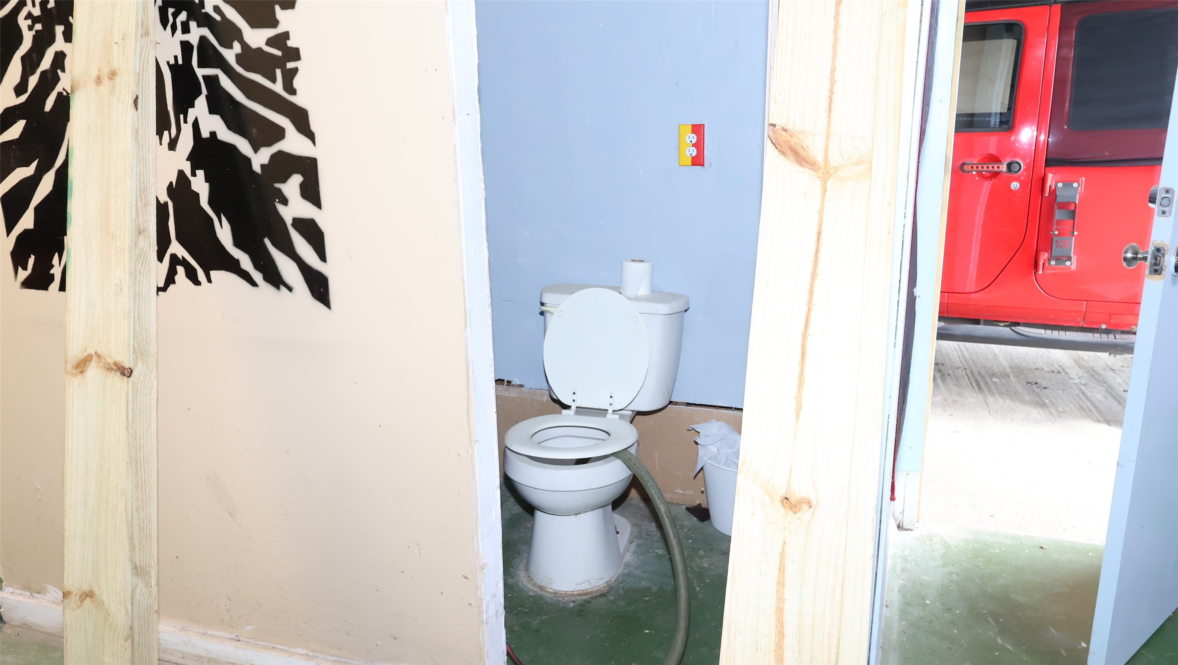 Compact bathroom space adjacent to a garage area.