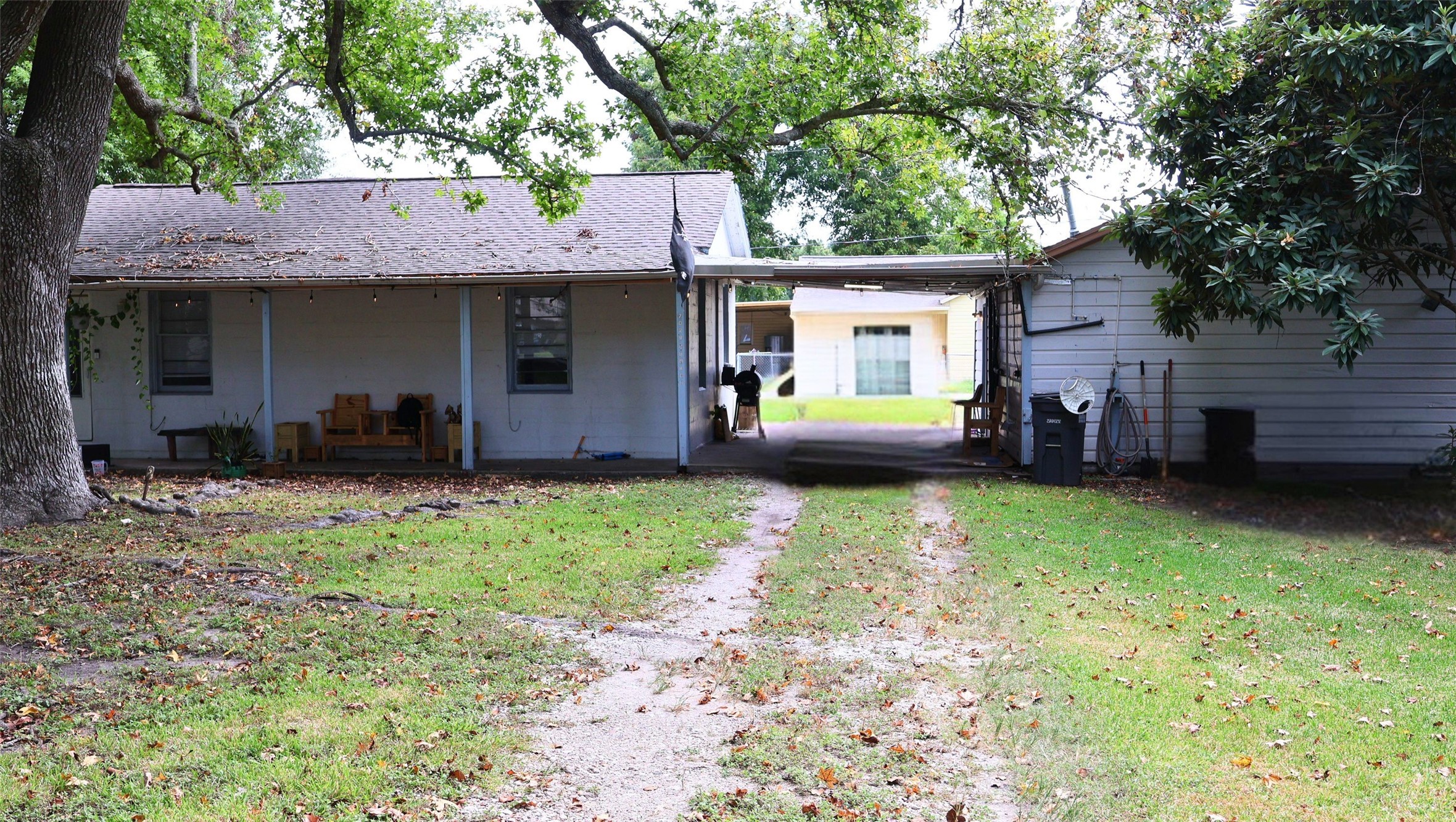 Charming front yard with mature trees, a covered patio for relaxation, and a driveway leading to convenient parking. Charming front yard with mature trees, a covered patio for relaxation, and a driveway leading to convenient parking.