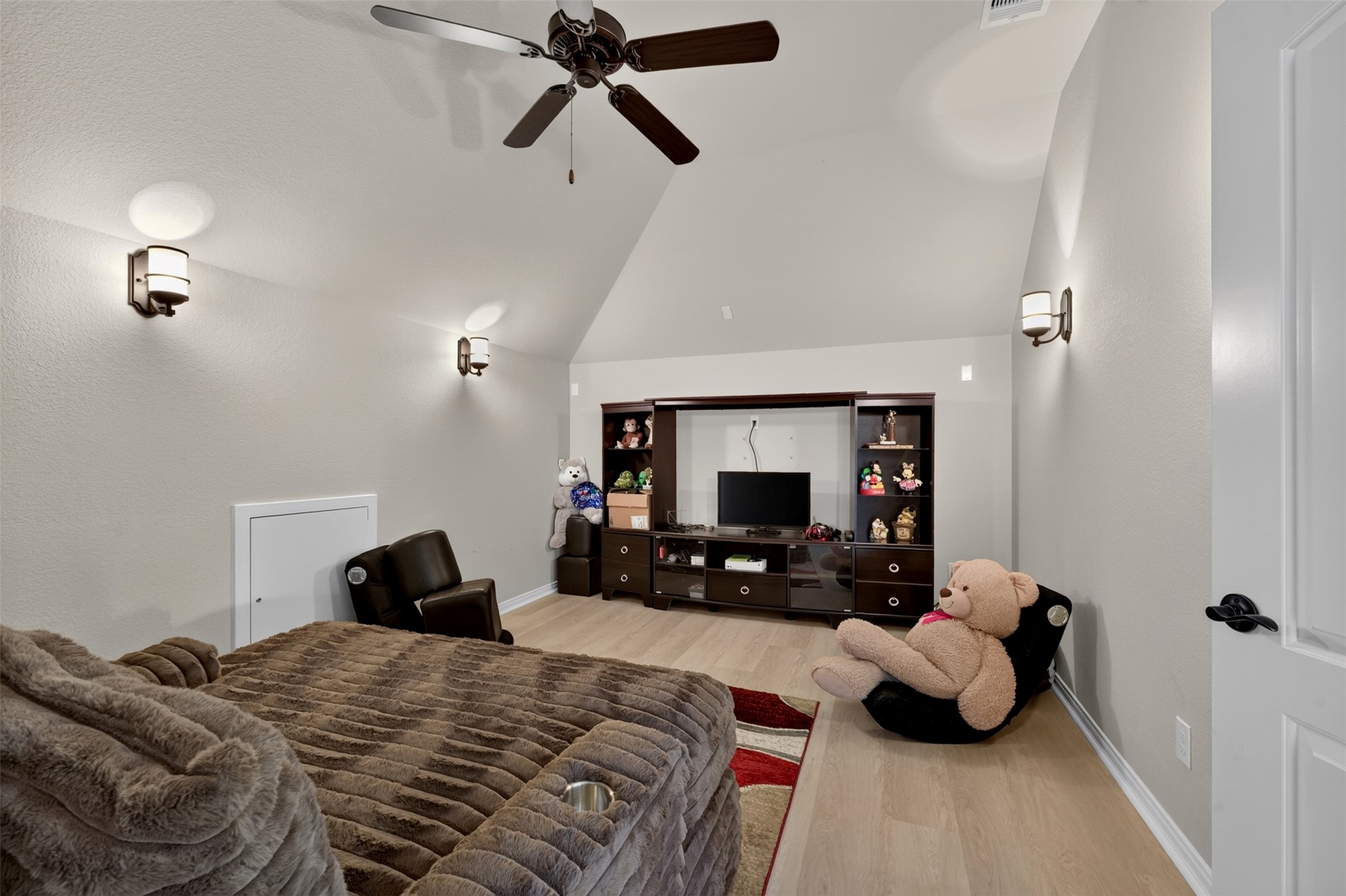 The media room offers a comfortable setting for movie nights, binge-watching your favorite shows, or enjoying game-day gatherings. Light-toned flooring and a ceiling fan complete this versatile space designed for relaxation and entertainment.