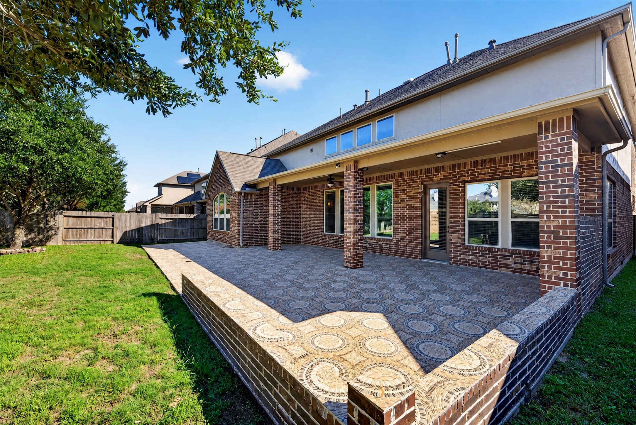 There's plenty of room to arrange multiple seating areas or an outdoor dining setup. Brick columns and the extended roofline provide a cohesive architectural finish.
