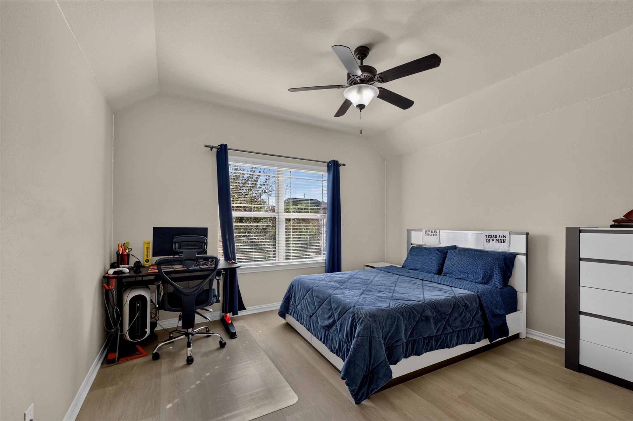 This spacious bedroom offers room for comfortable furnishings while maintaining an open, inviting feel. A large window brings in natural light.