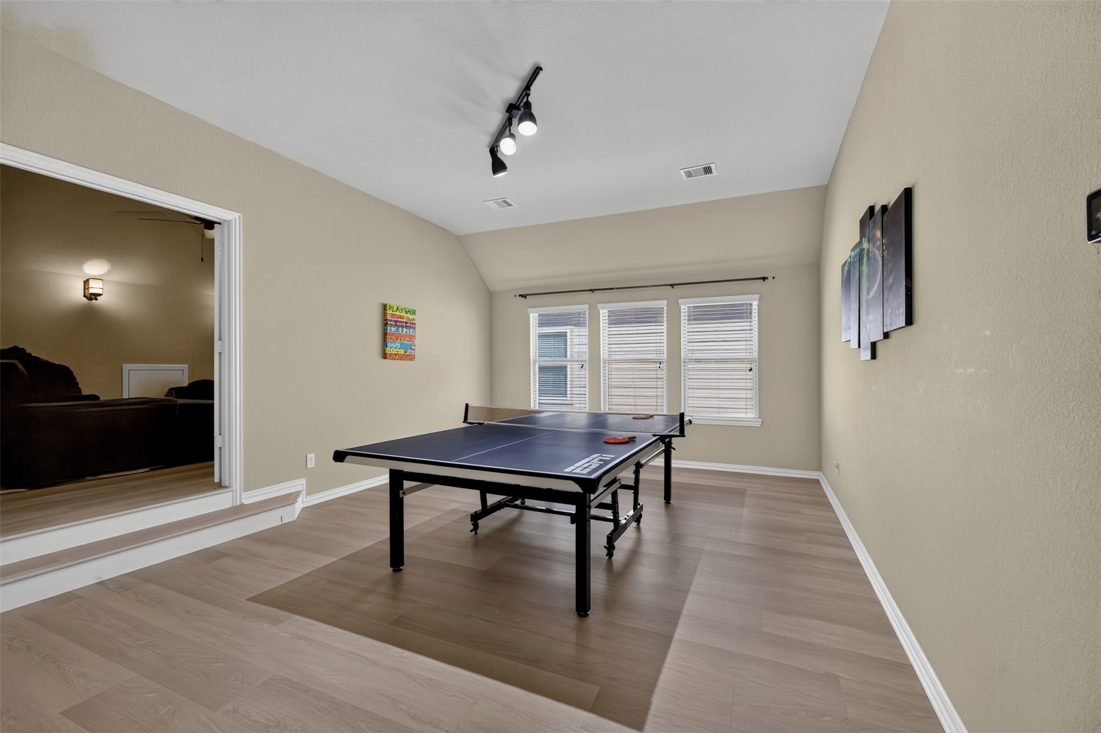 Head upstairs to a spacious game room with plenty of room for a pool table, game tables, or your favorite entertainment setup. Natural light streams through the windows, creating an inviting space for recreation, hobbies, and gatherings with family and friends.