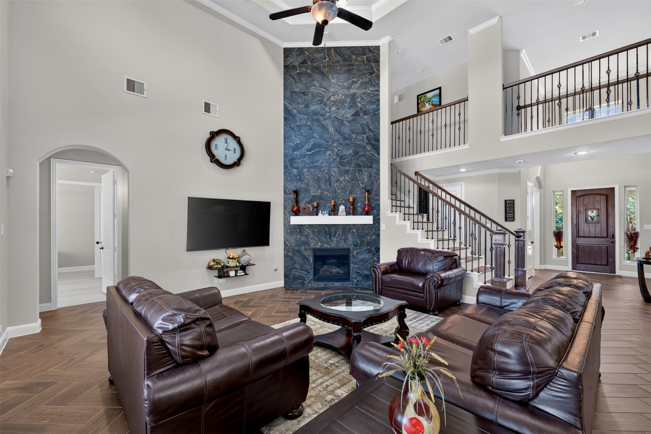 A striking cast stone fireplace creates a beautiful focal point, adding character and visual interest to the space. The elevated ceiling enhances the home's open, airy feel.