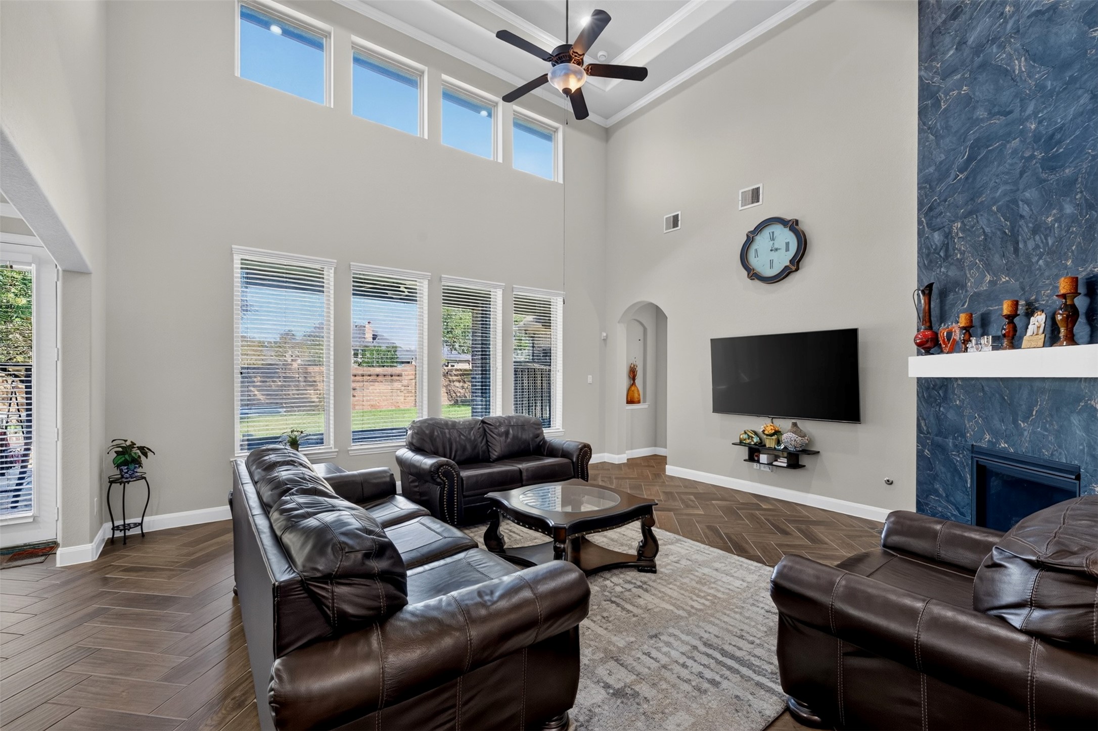 The family room makes a dramatic impression with soaring ceilings, tall windows, and an abundance of natural light. The open layout offers plenty of room to relax and gather.