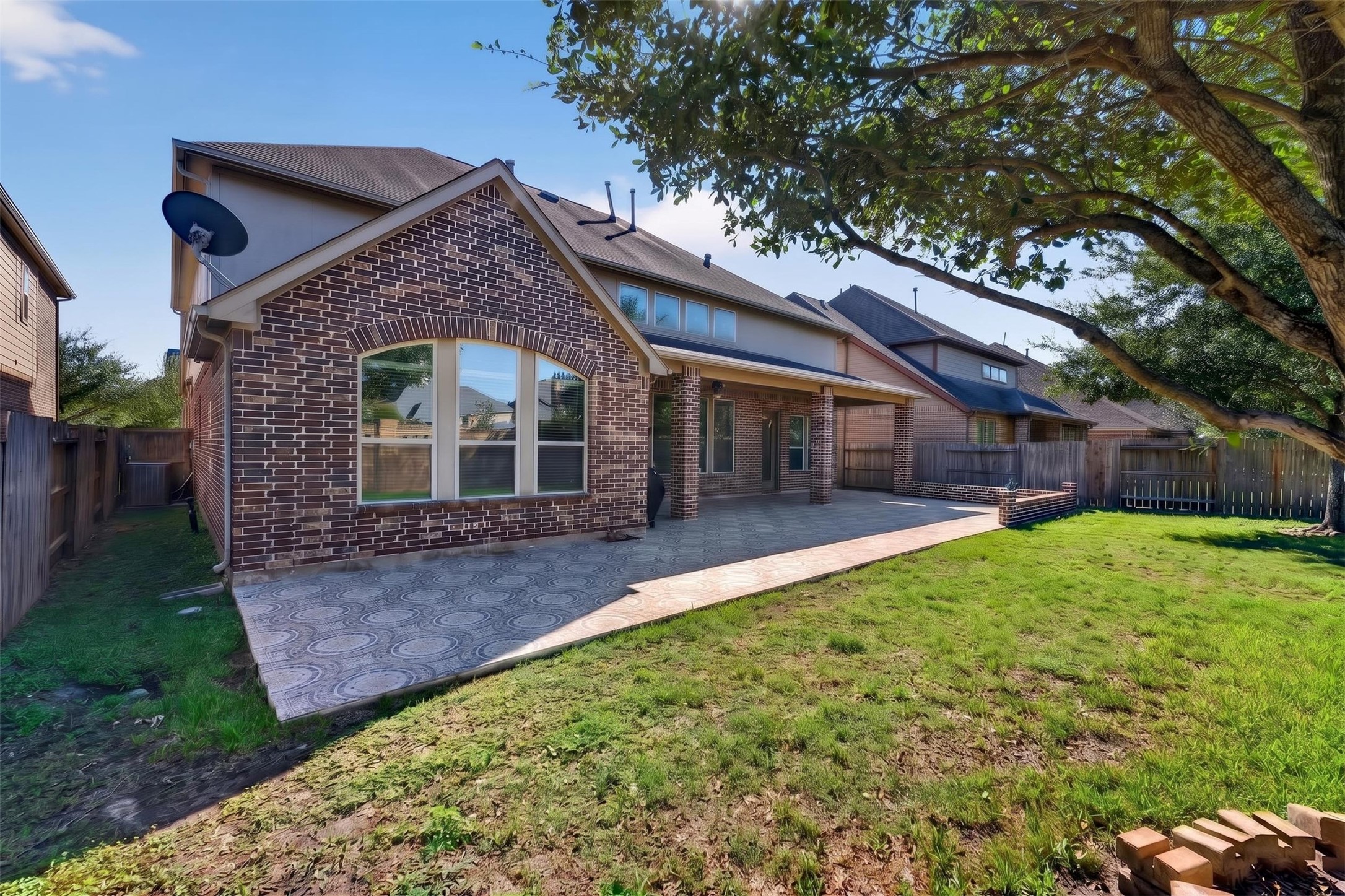 Enjoy another perspective of the outdoor space, highlighting the broad patio and grassy yard.