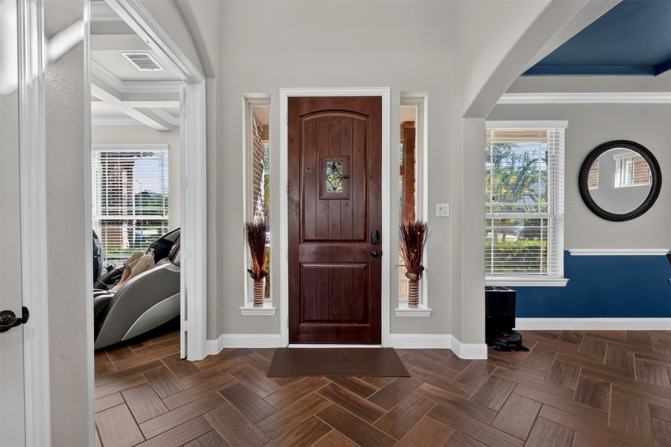 Step through the front door and into a welcoming entry that immediately sets the tone for this gorgeous home. Elegant sidelights invite natural light inside, while the herringbone-pattern wood-look tile creates a stylish first impression and leads you toward the home's inviting living spaces.