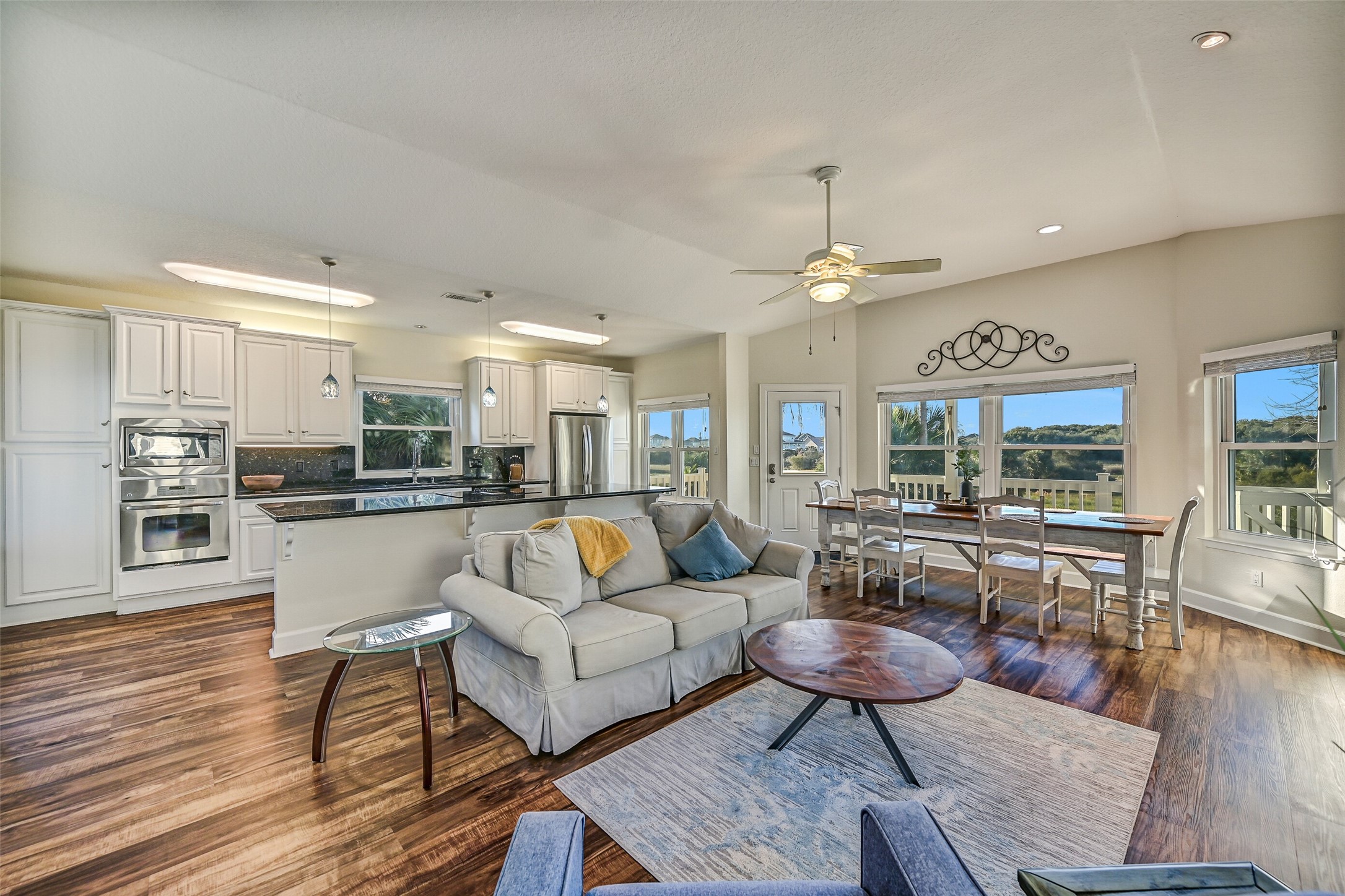The ground level hosts an open kitchen, living, and dining room, a half bath, laundry room, and the expansive primary suite.