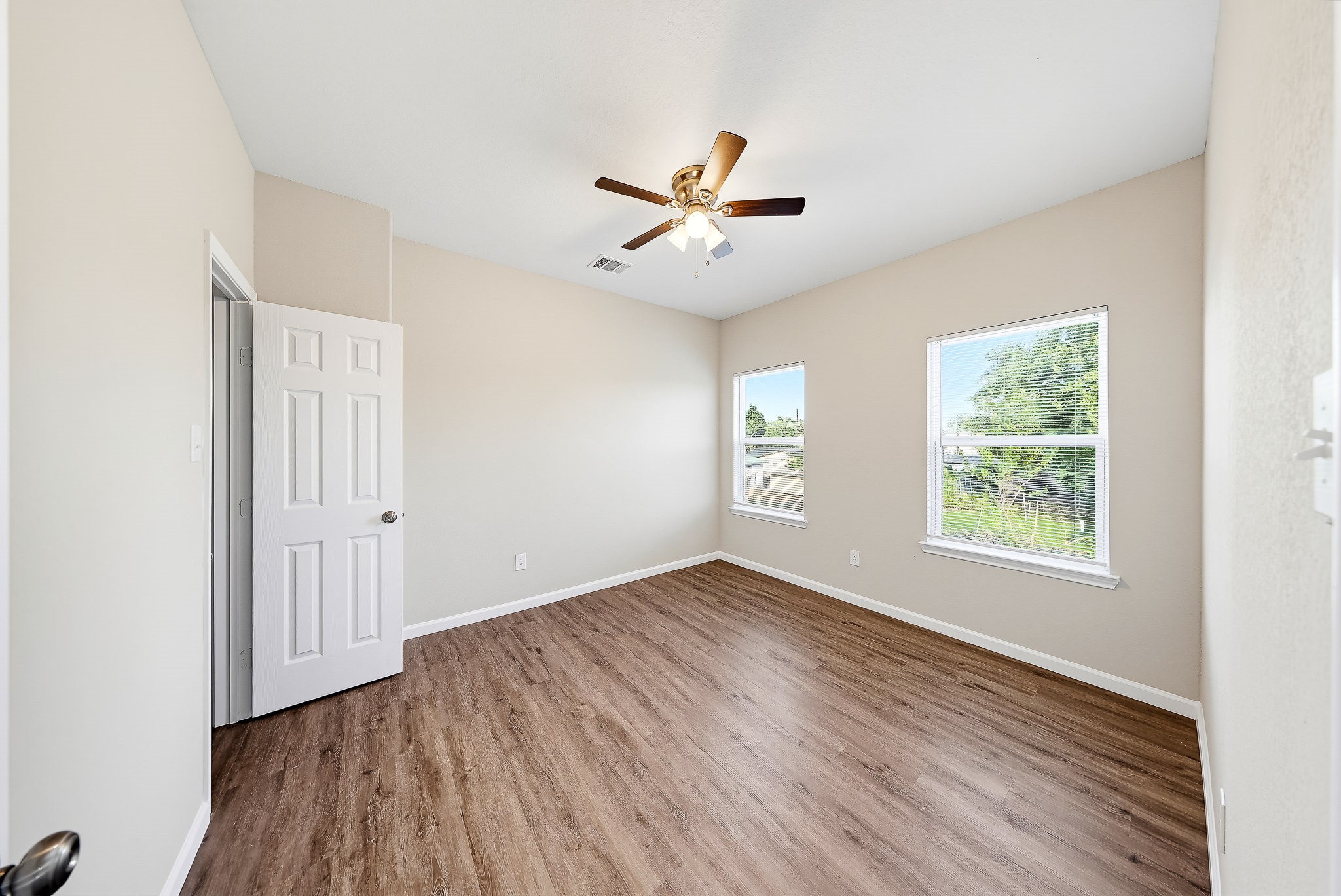Bring your vision to this bright secondary bedroom with warm-toned flooring.