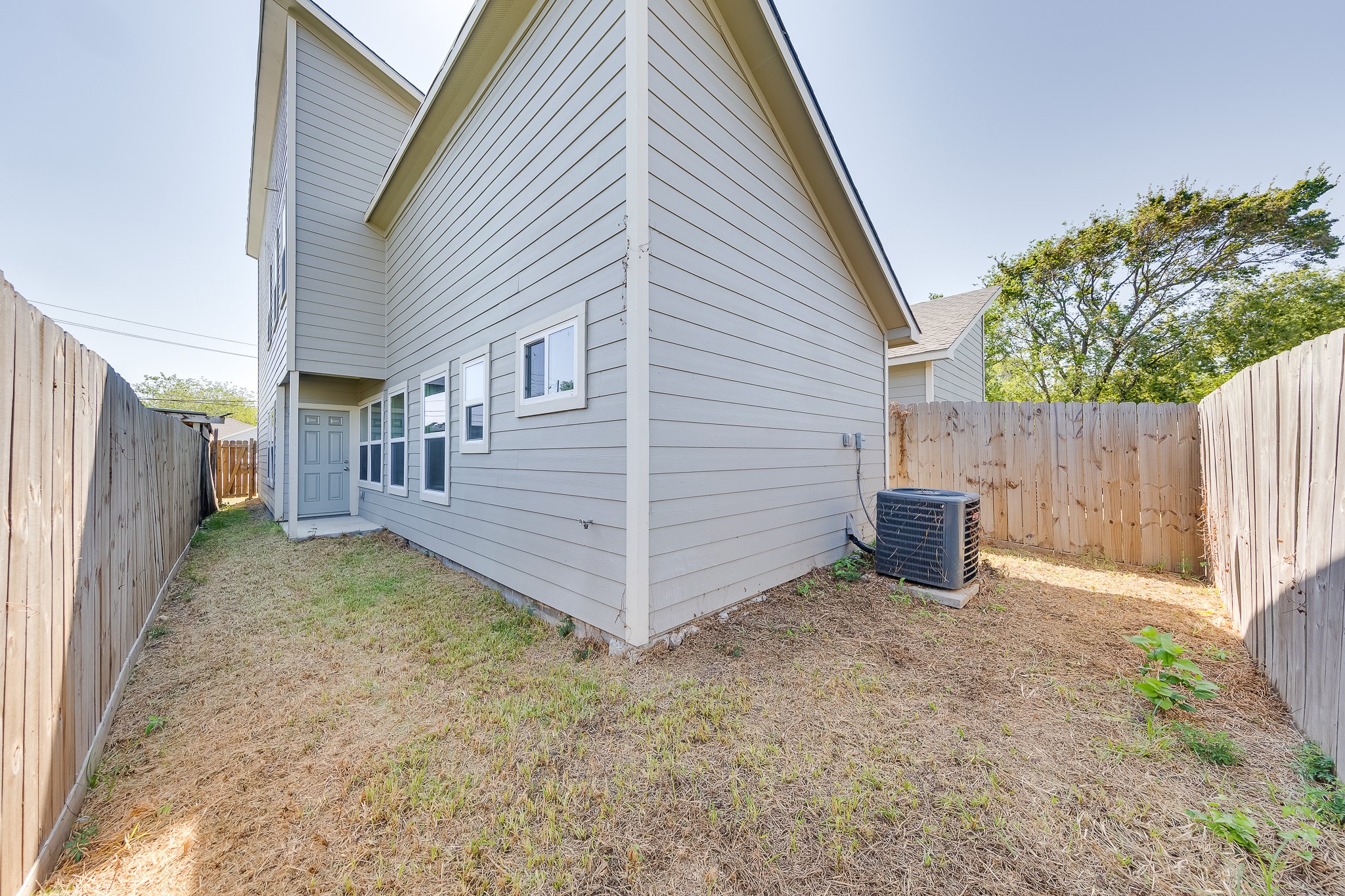 Add a few outdoor chairs and plants to make this fenced backyard your own little retreat.