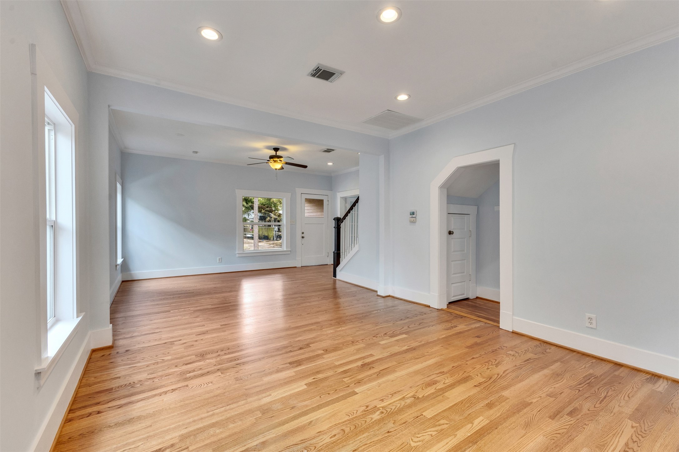 Spacious living area with beautiful hardwood floors, recessed lighting, and large windows offering plenty of natural light.