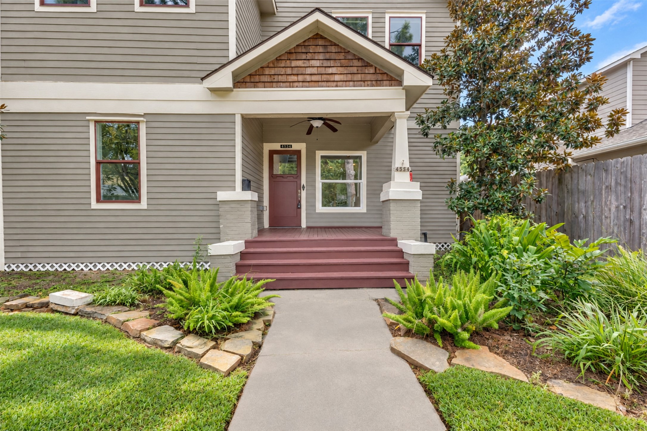 Charming home with classic appeal features a welcoming front porch, lush landscaping, and a well-maintained exterior.