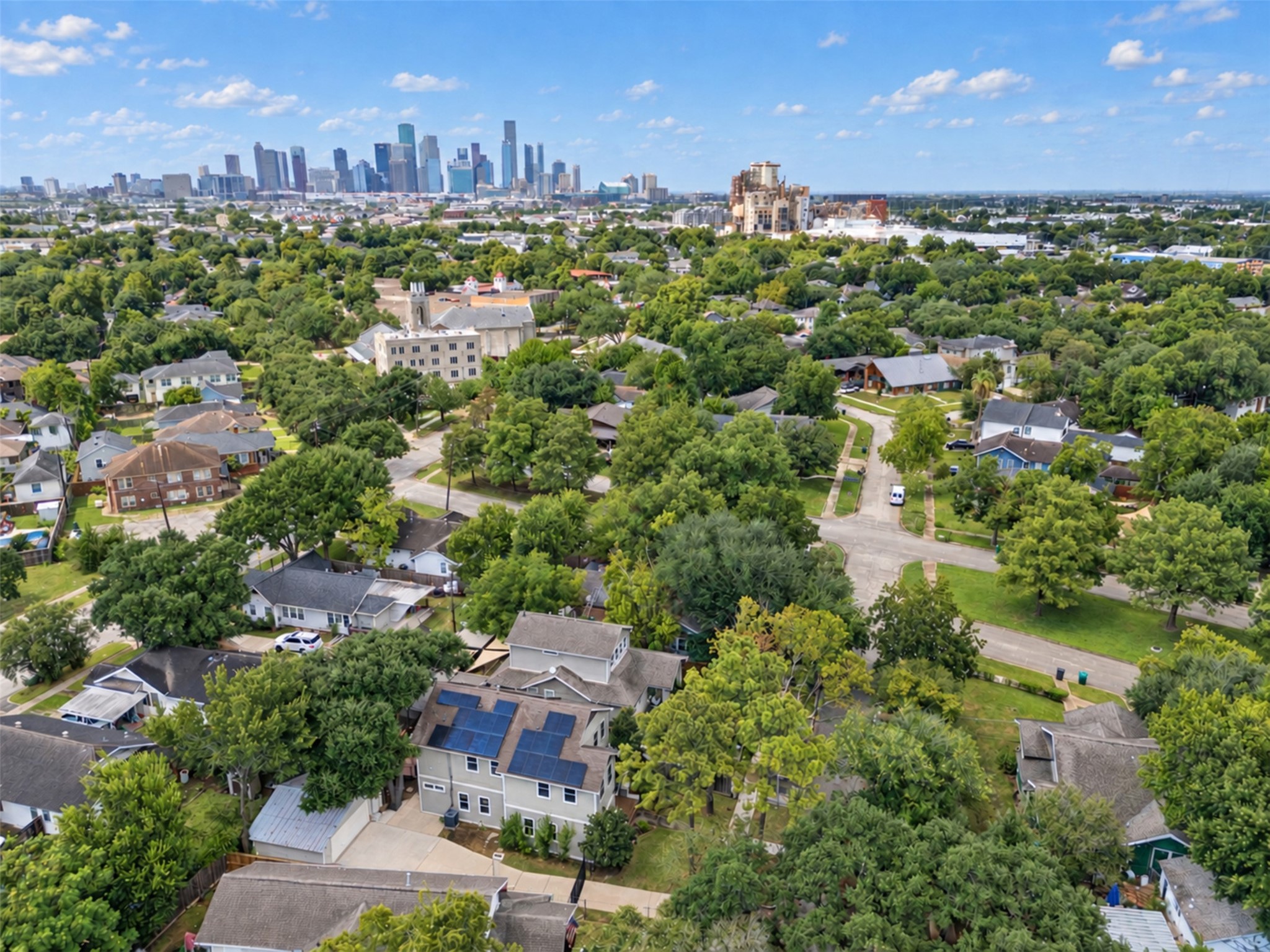Charming neighborhood with lush greenery, offering a serene residential feel with convenient proximity to the vibrant city skyline in the distance.