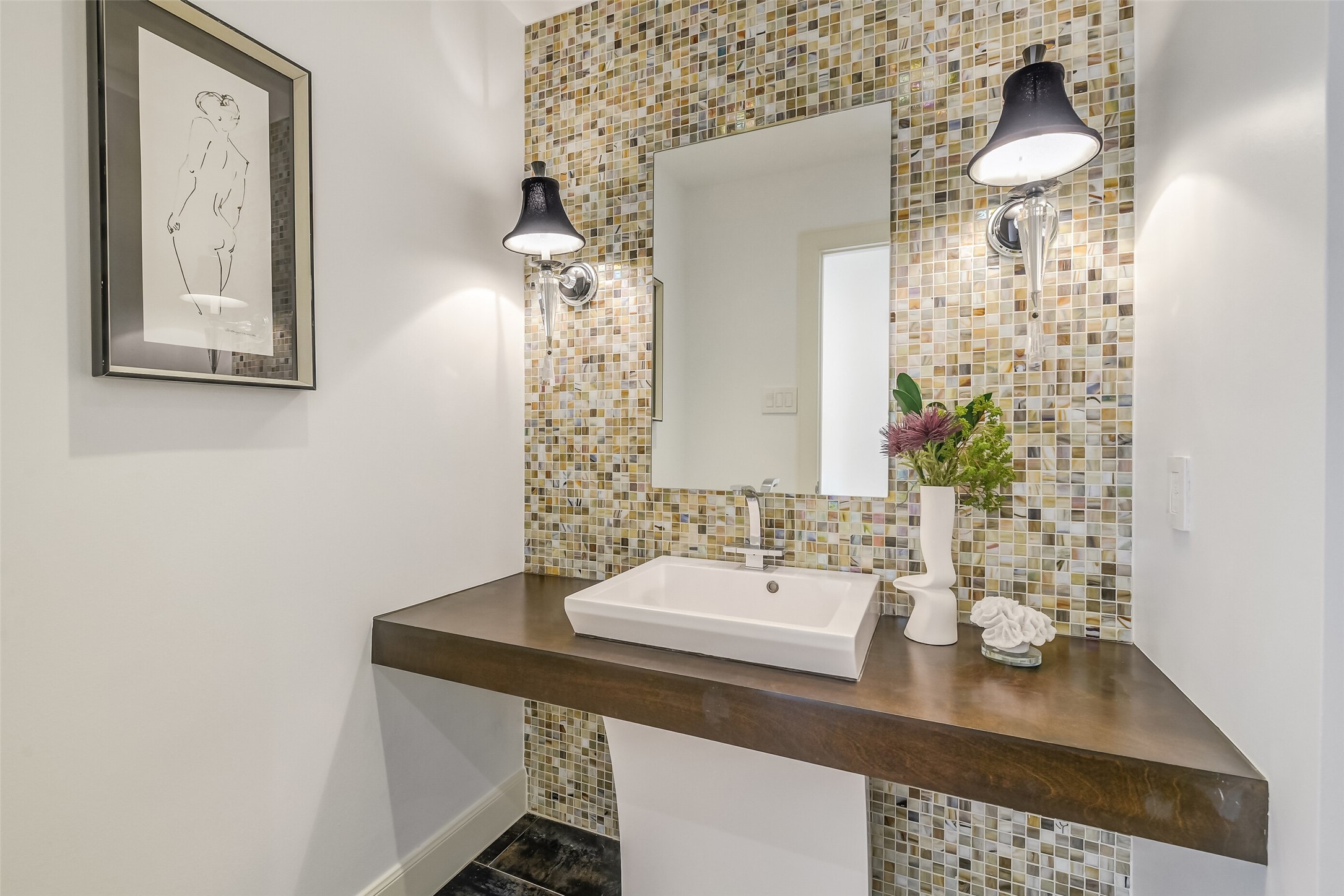 Elegantly appointed half bath featuring a modern floating vanity, stylish fixtures, and a sophisticated design ideal for guests.