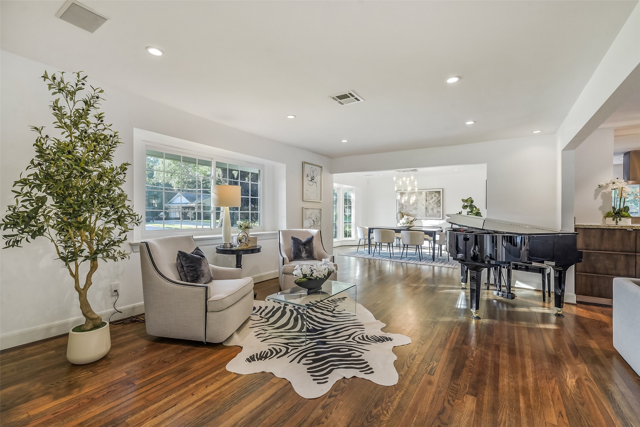 A bright and inviting formal living area welcomes you into the home, filled with natural light and thoughtfully designed to flow seamlessly into the formal dining room, family room, and kitchen.