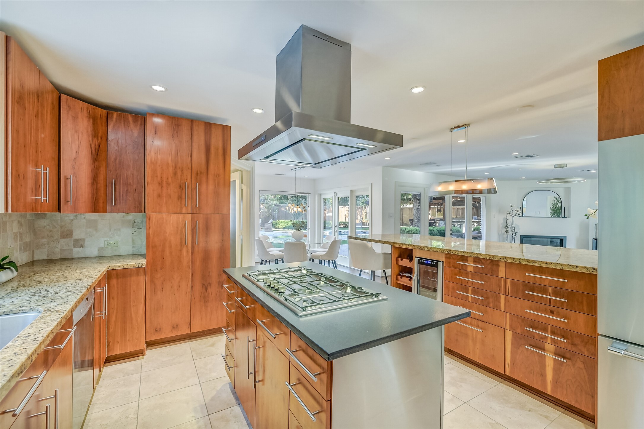 Thoughtfully designed for effortless entertaining, the kitchen flows seamlessly into the living and breakfast areas, featuring generous counter space, breakfast bar seating, a wine refrigerator, and convenient access to the formal dining room.