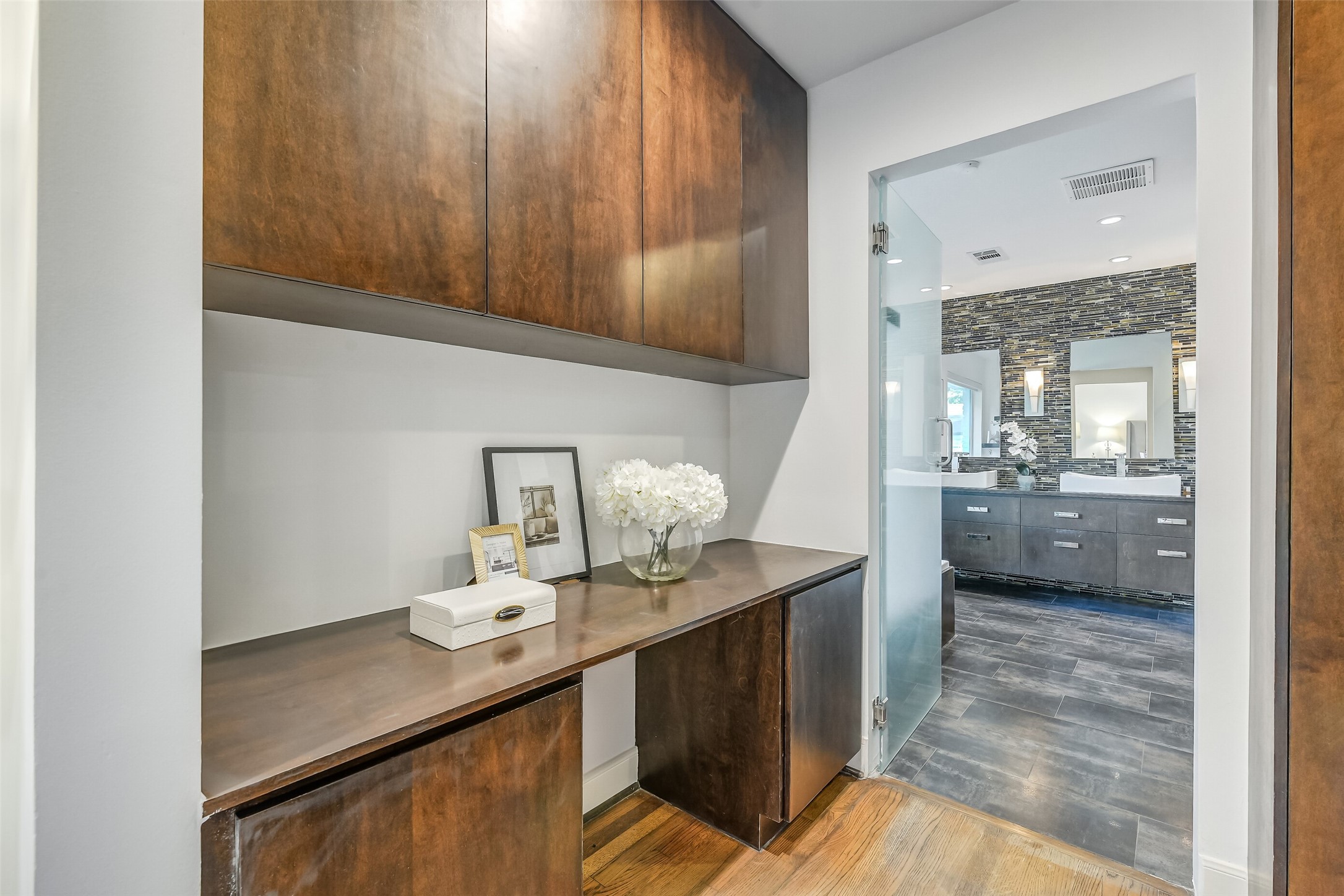 Thoughtfully designed connecting space between the primary bedroom and bath, featuring a custom built-in vanity with generous counter space and ample storage for added comfort and convenience.