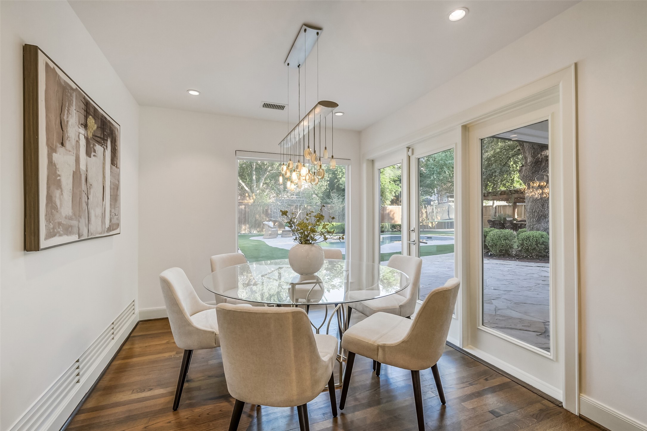 Bright and inviting breakfast nook featuring expansive picture windows and a door leading to the beautiful backyard and pool. Open to the kitchen and family room, this light-filled space offers seamless flow and lovely views, perfect for casual dining and everyday enjoyment.