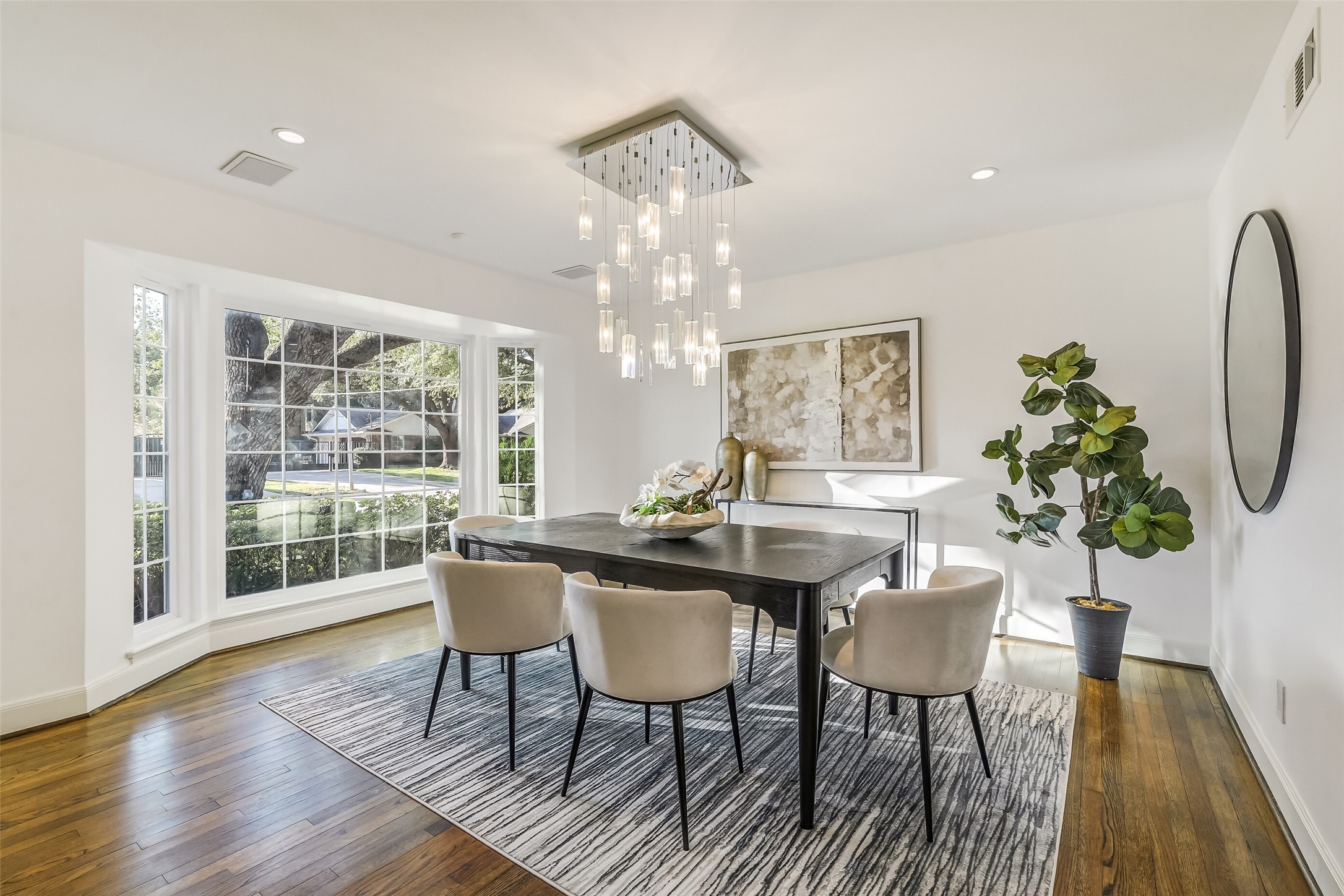 Spacious and elegant formal dining room featuring expansive bay windows that fill the space with natural light while offering picturesque views, creating a beautiful setting for intimate dinners and memorable gatherings.