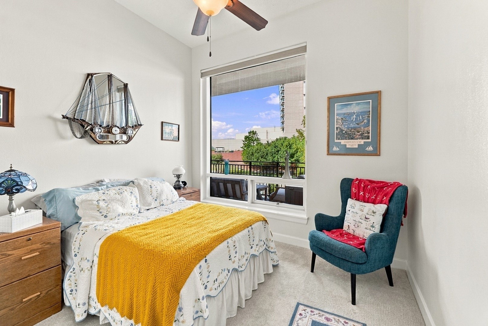 Light-filled bedroom with a large window, ceiling fan, and comfortable space to relax and unwind.