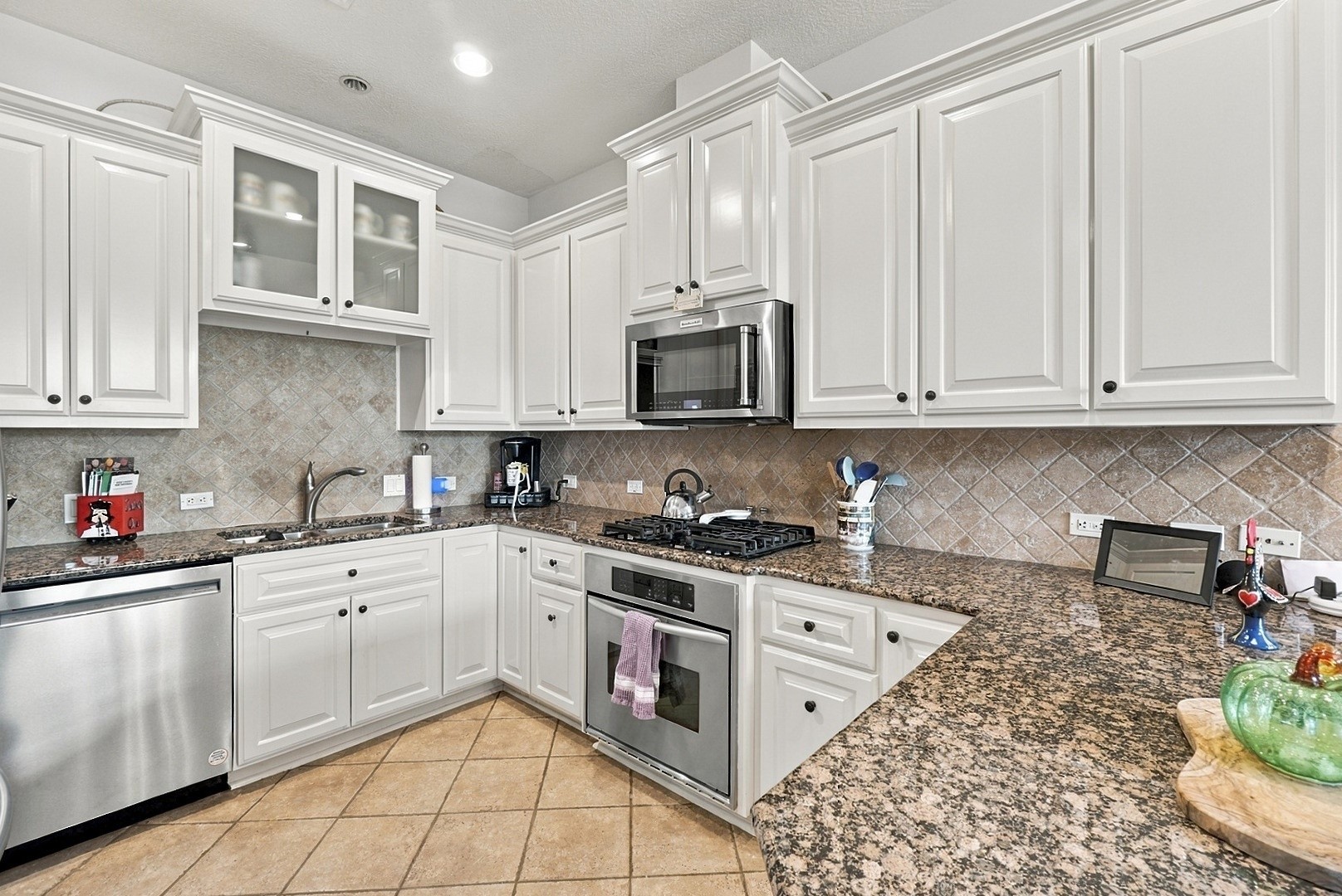 Crisp white cabinetry, granite countertops, stainless steel appliances, and generous storage throughout.