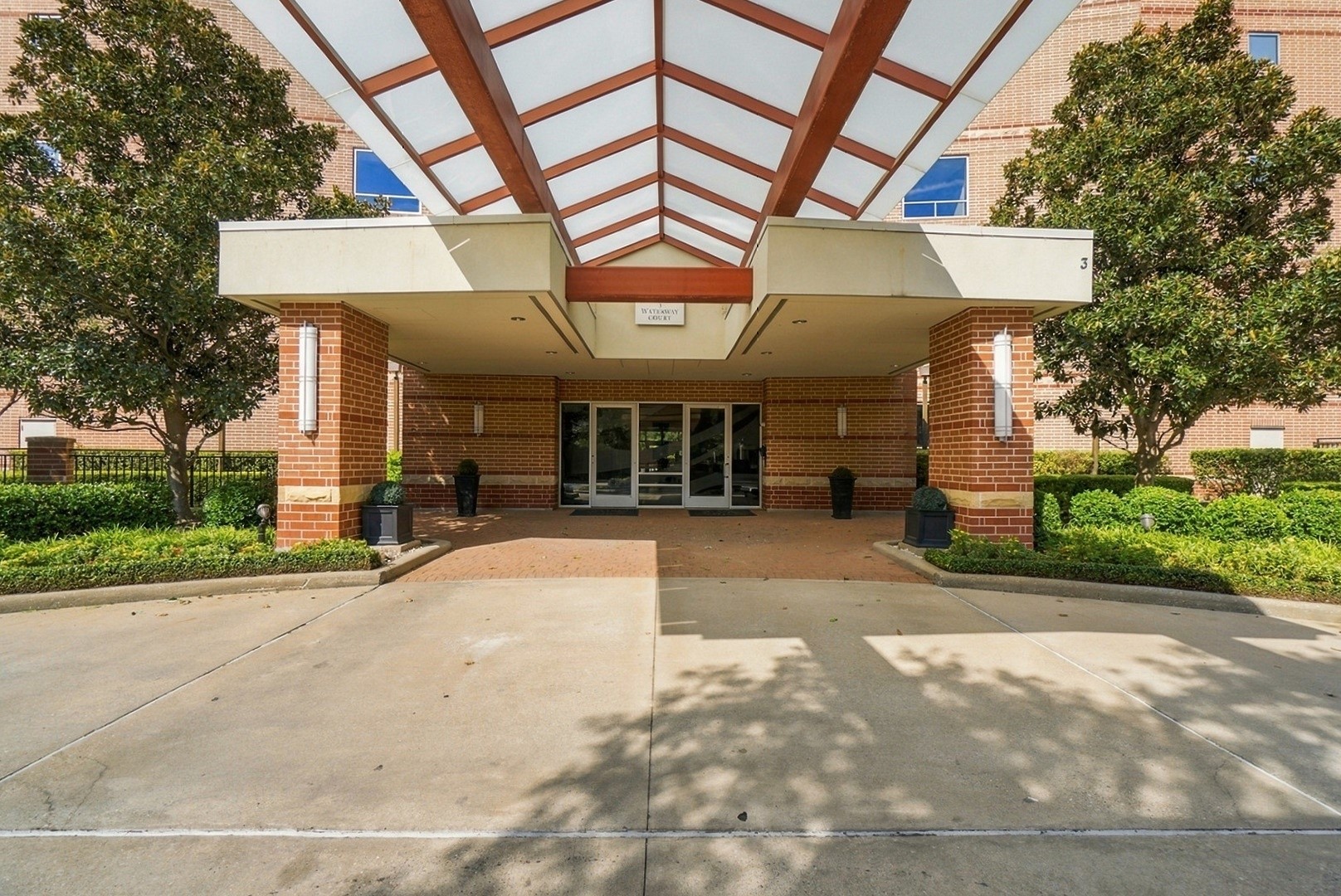 Welcoming building entrance featuring a spacious covered drive and attractive architectural design.