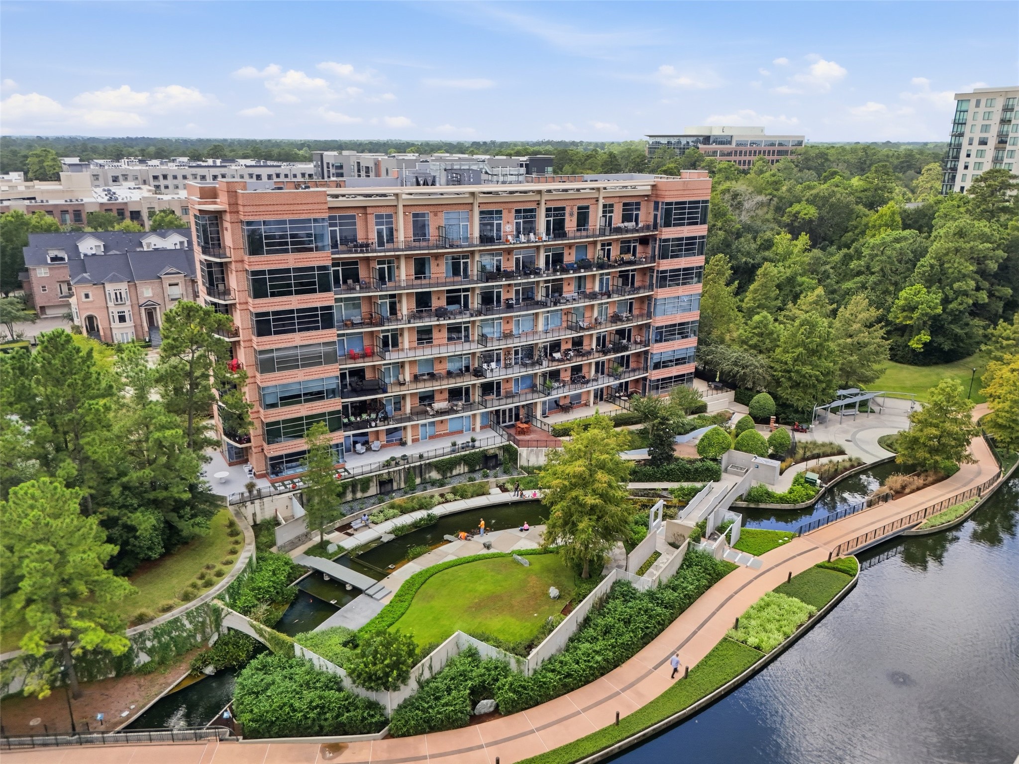 Luxury condominium living surrounded by lush landscaping and the scenic Woodlands Waterway.