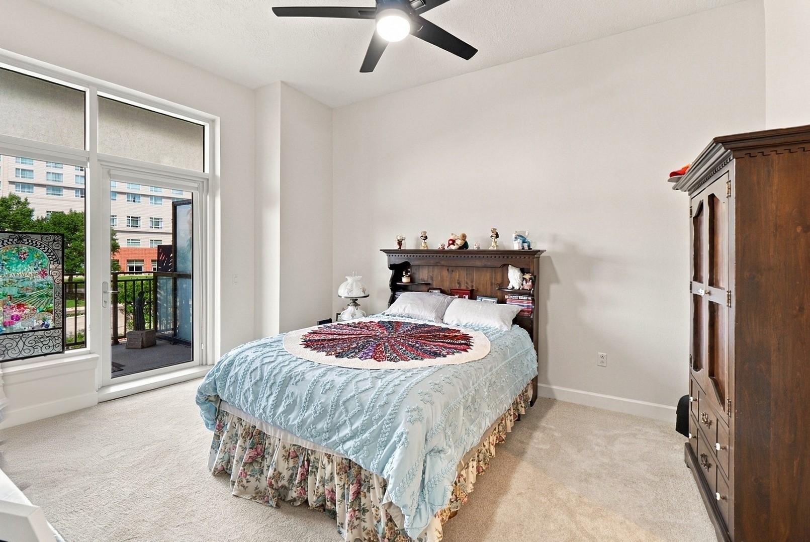 Spacious bedroom with soft natural light, a ceiling fan, and access to the private balcony.