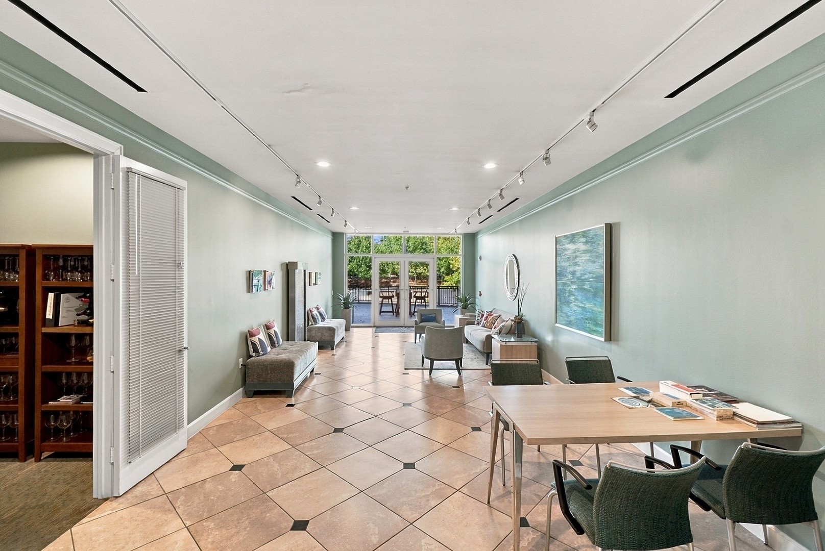 Spacious common area with abundant natural light, elegant tile flooring, and inviting seating arrangements.