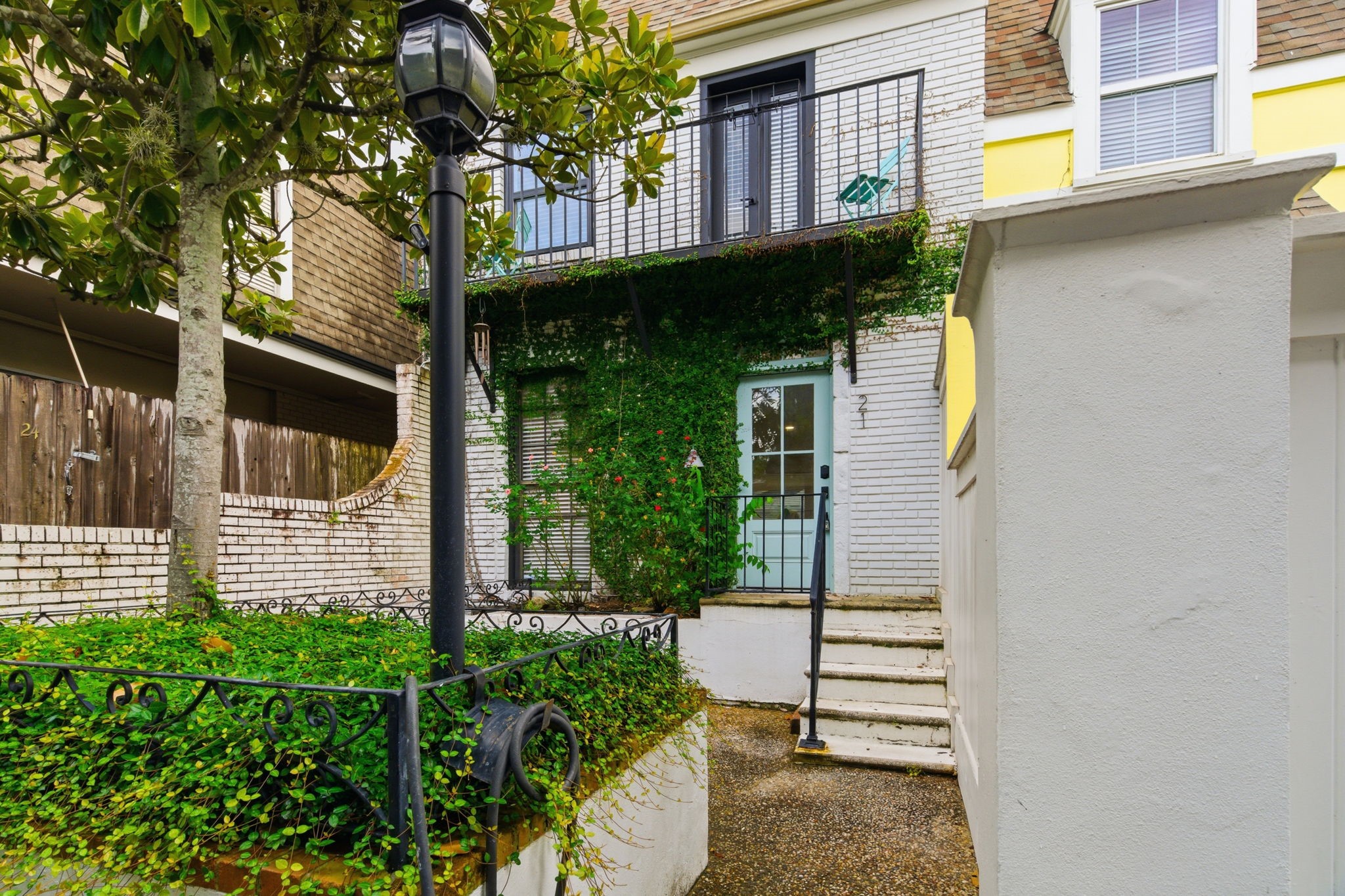 The homes courtyard entry is framed by established greenery, flowering plants, and classic brickwork. The homes courtyard entry is framed by established greenery, flowering plants, and classic brickwork.