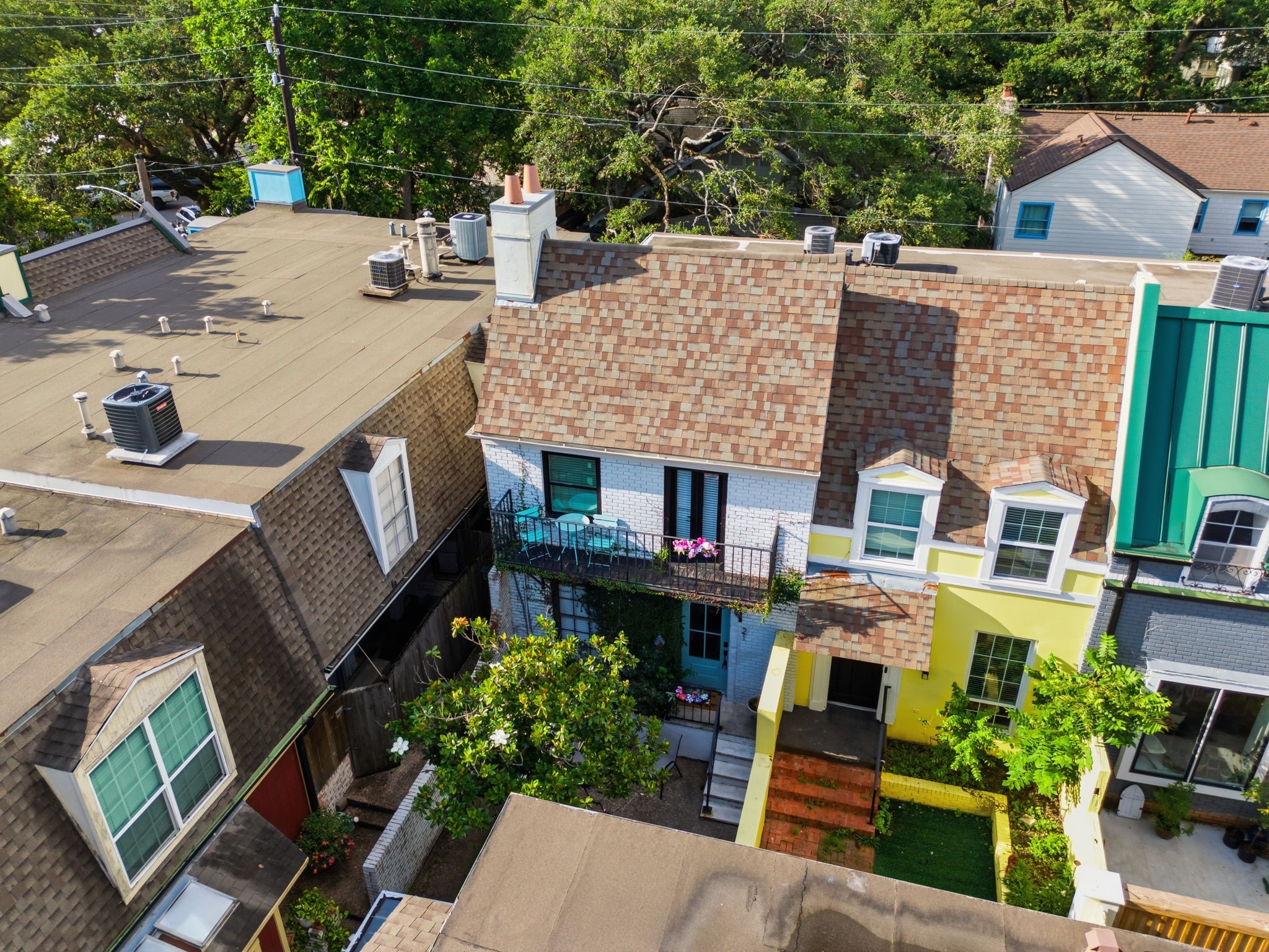 This view captures the homes two story design, upper balcony, courtyard entry, and distinctive architectural character.