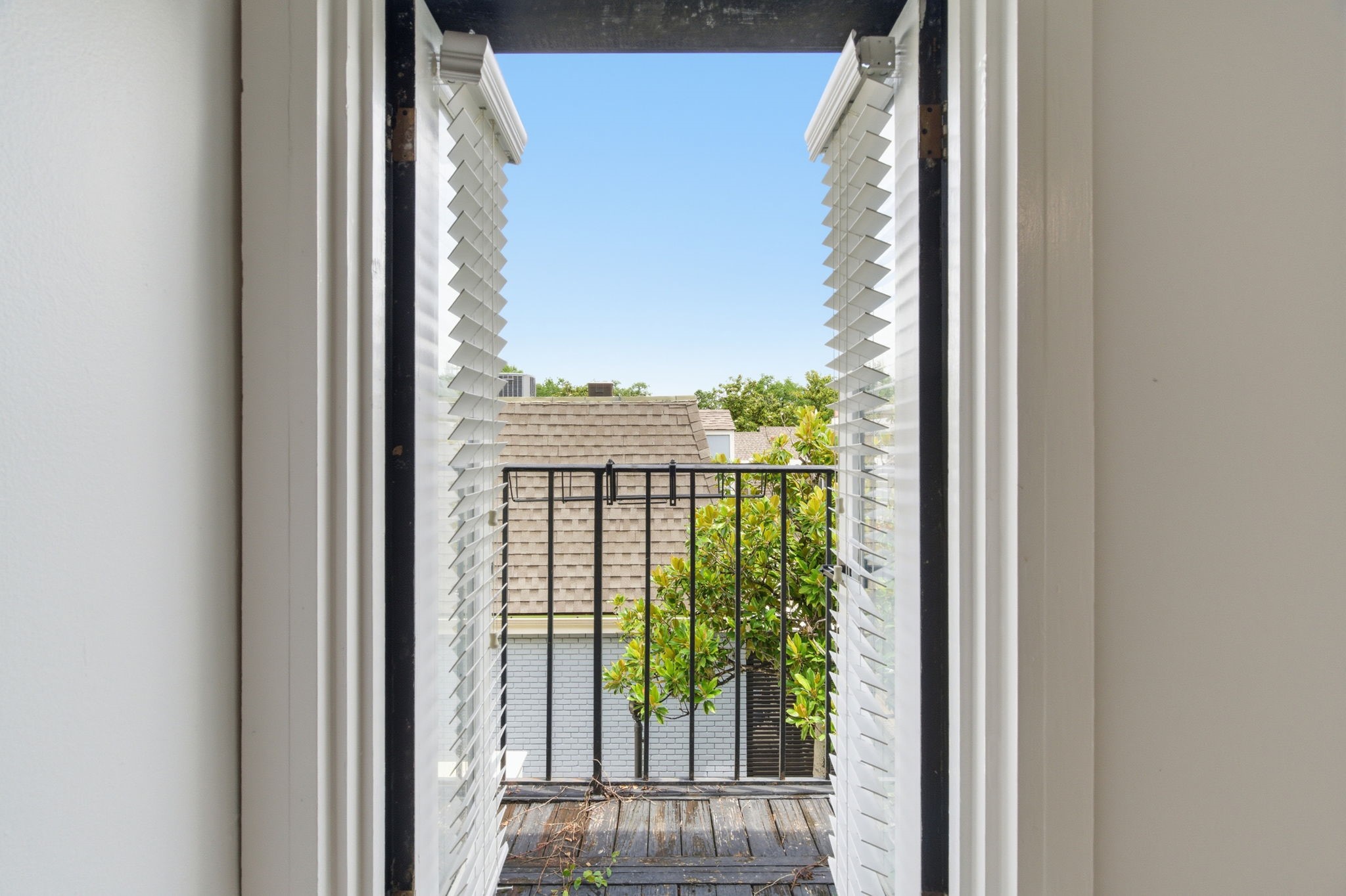 Open the shuttered doors and step directly from the primary bedroom onto the private balcony.