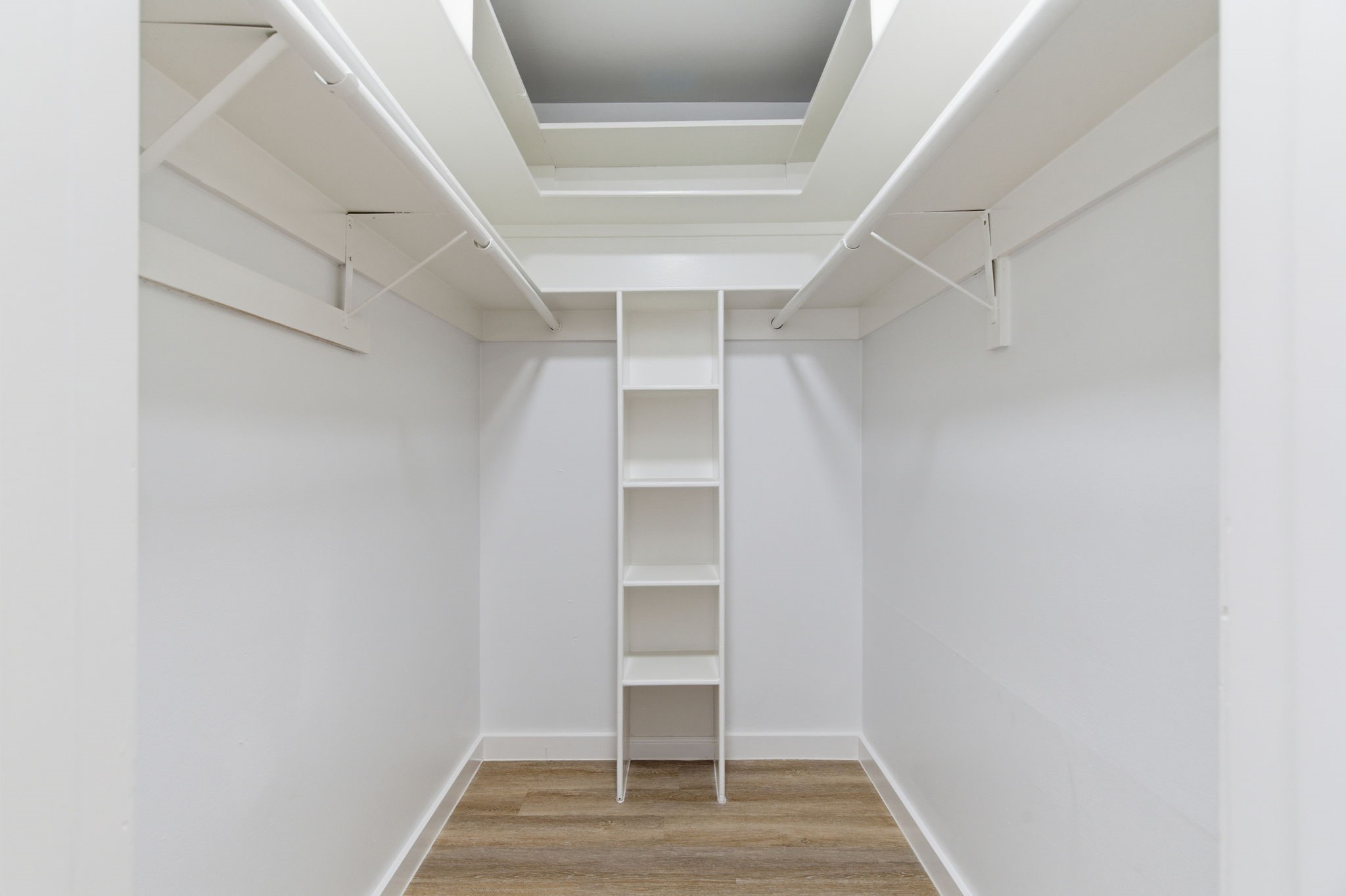 The walk in closet provides hanging space on both sides along with built in shelving for added organization.