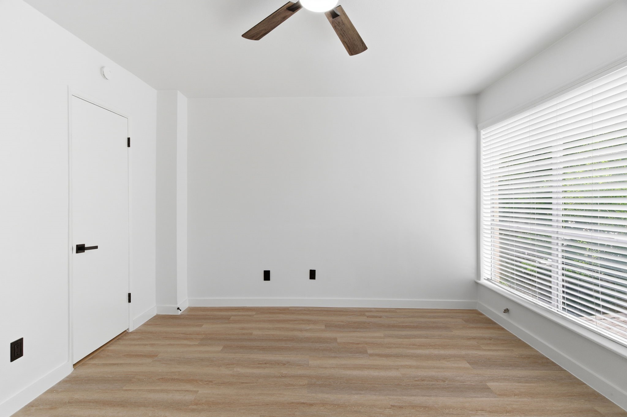 Another angle shows the secondary bedrooms closet storage, modern ceiling fan, and flexible layout.