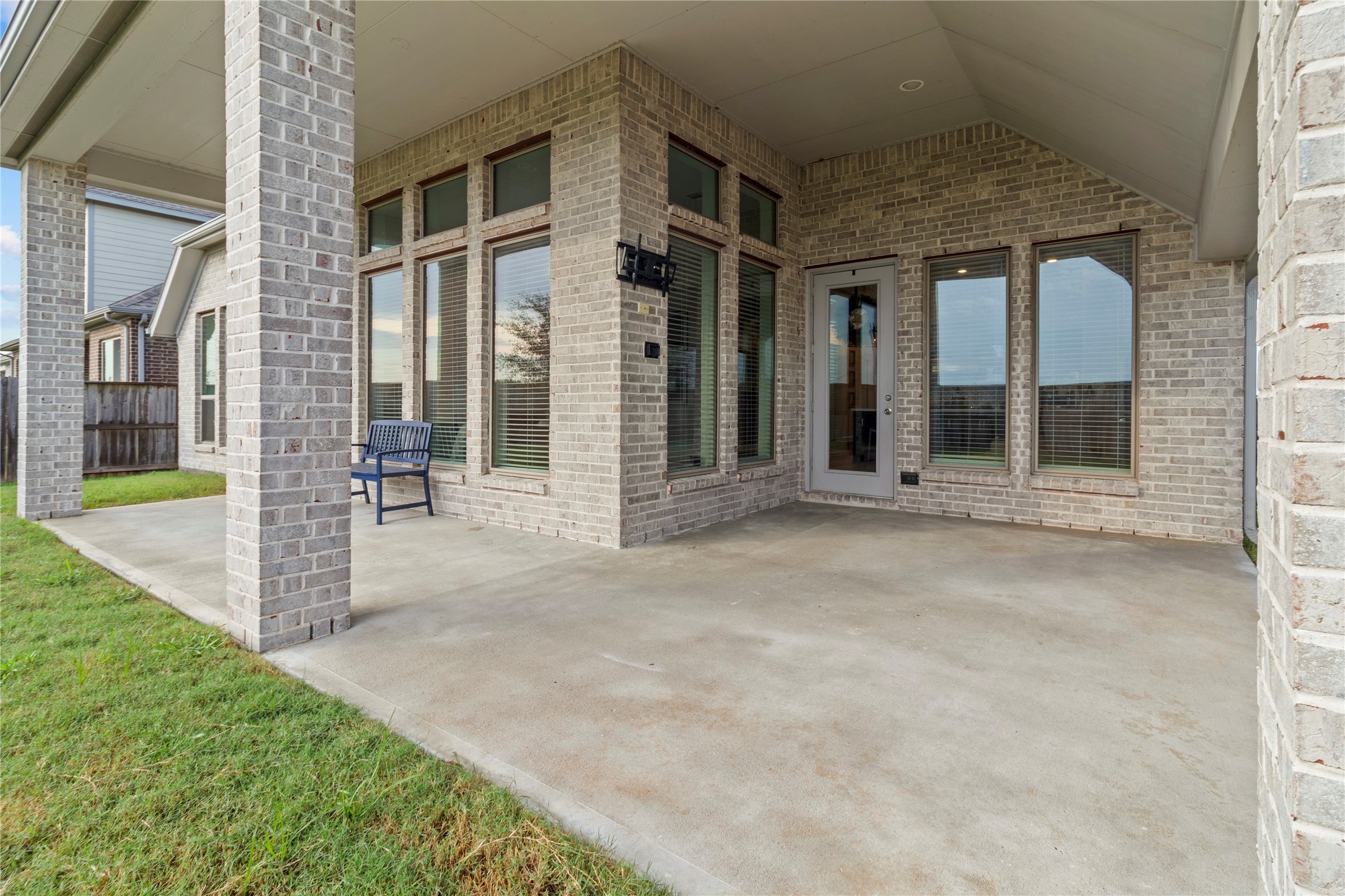 Spacious covered patio with elegant brickwork and large windows, perfect for outdoor entertaining and relaxation.