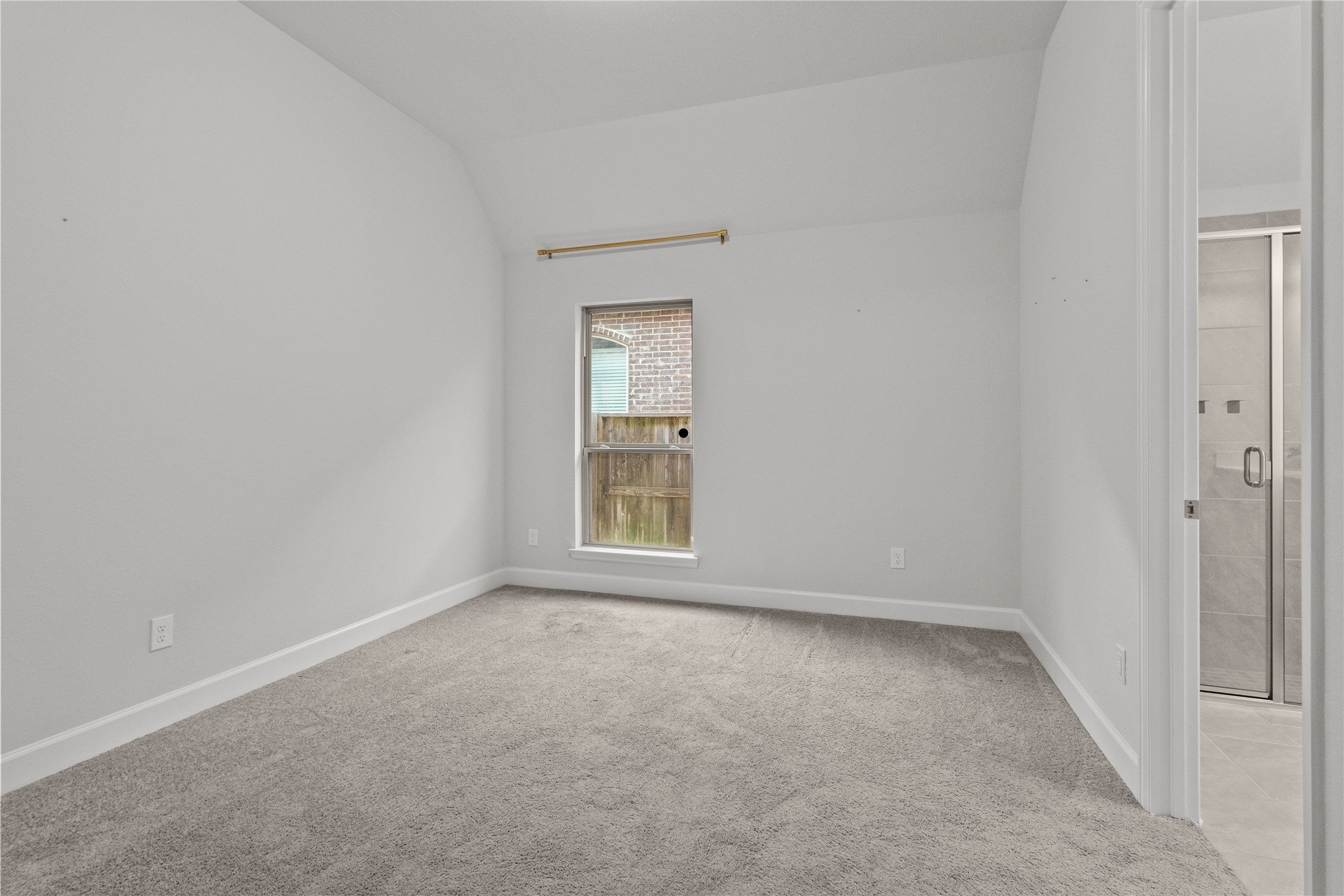 Bright and cozy room with soft carpeting, a window for natural light, and an adjacent bathroom for convenience. Bedroom 2 with attached bathroom.