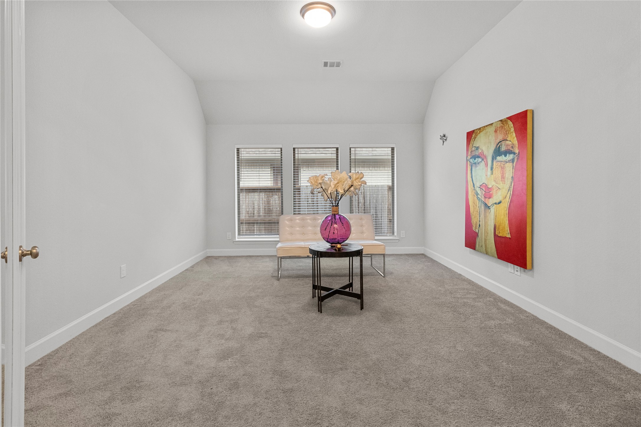 Elevate your work-from-home experience in this bright office, elegantly enclosed by glass French doors.