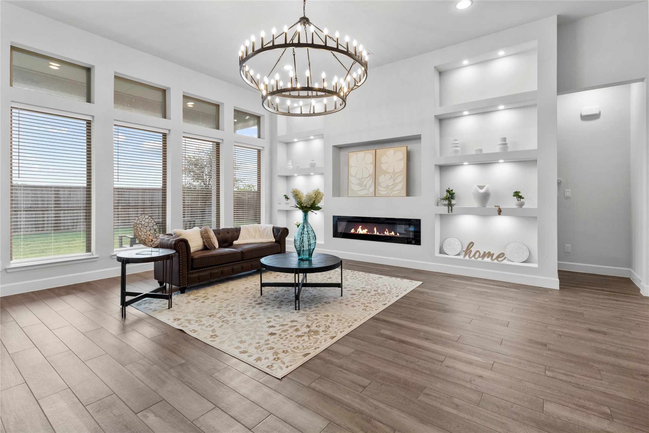 Elegant living room with a modern fireplace, built-in shelving, and large windows offering plenty of natural light.