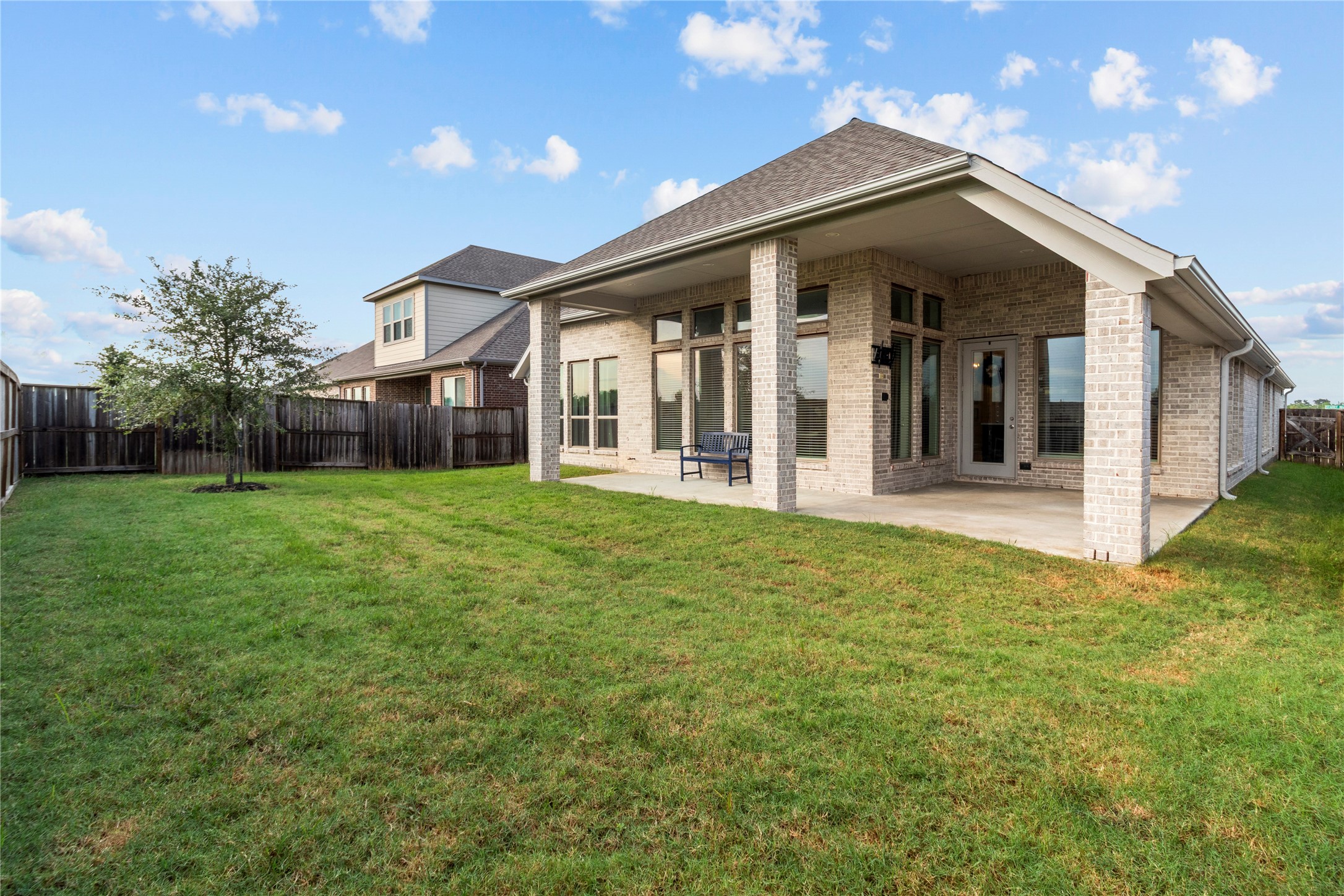 Charming brick home with a spacious covered patio overlooking a lush, fenced backyardperfect for outdoor relaxation and entertaining.