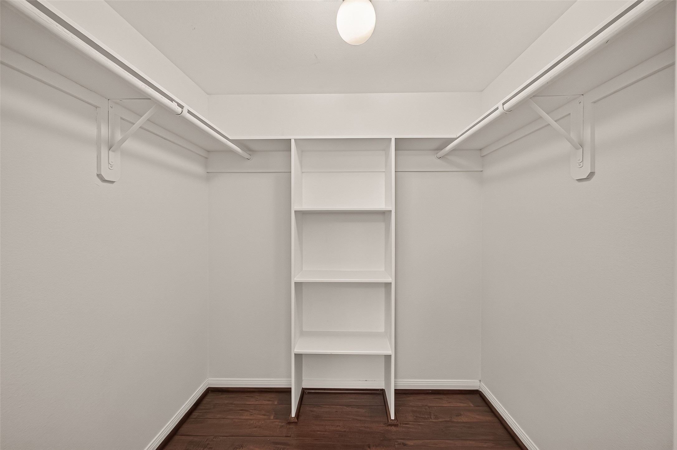 Spacious walk-in closet featuring dual hanging rods and built-in shelving for optimal organization.