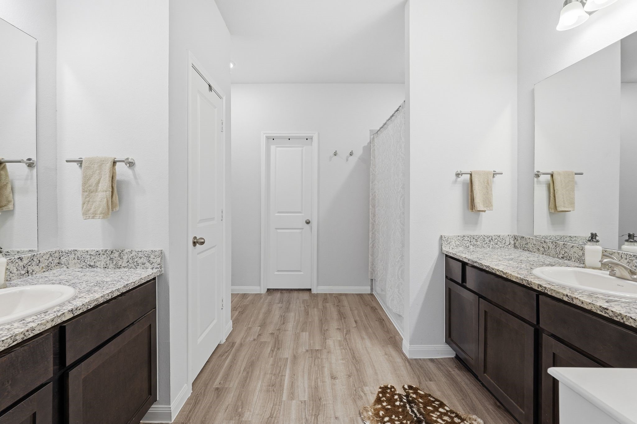 Large primary bathroom with double sinks and a shower and tub