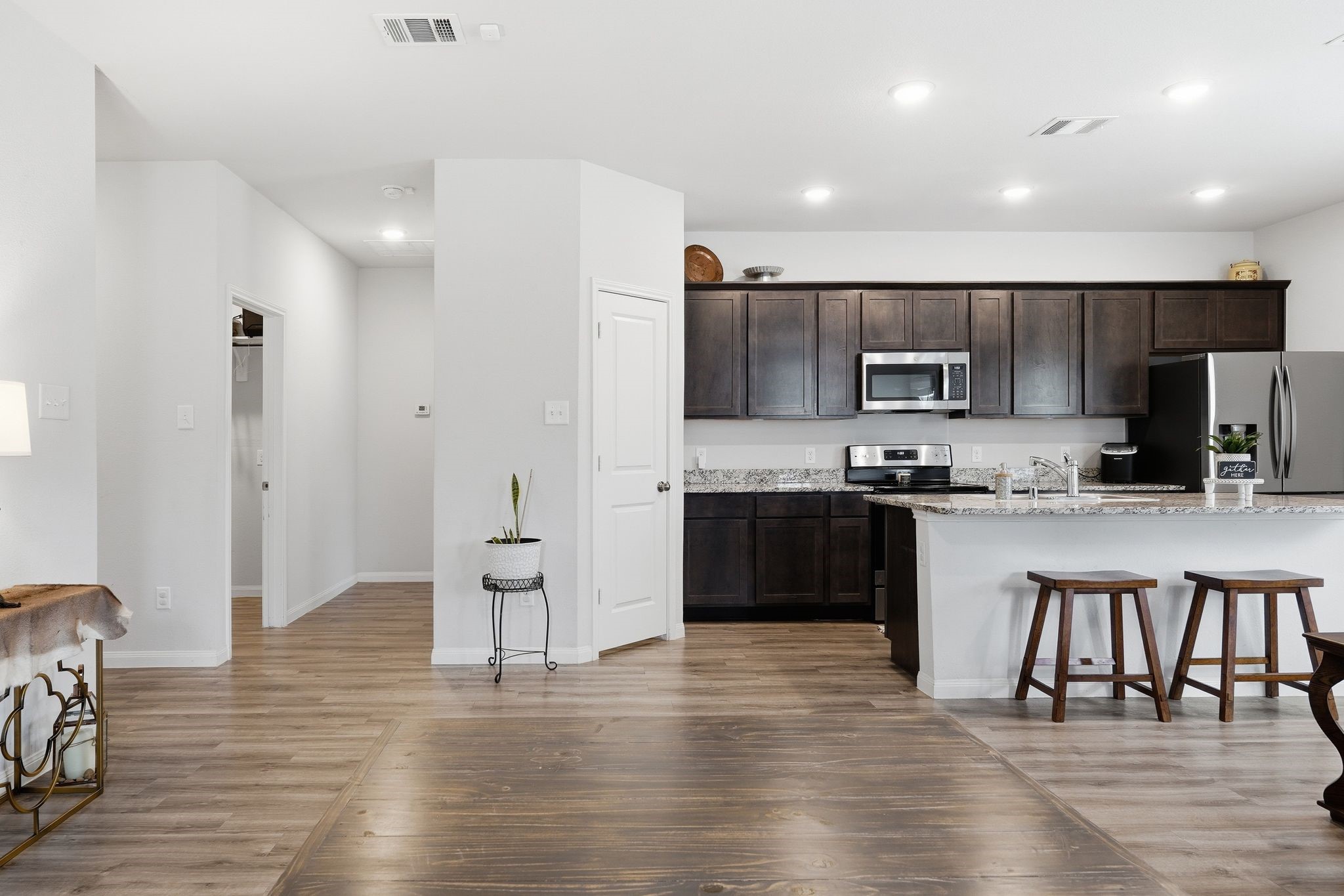 Hall off of the kitchen leads to the utility room and primary bedroom