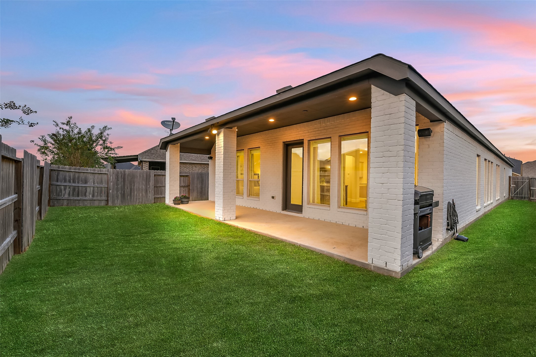 This beautiful backyard has a large covered porch, perfect for entertaining or relaxing with friends and family, complete with speakers.