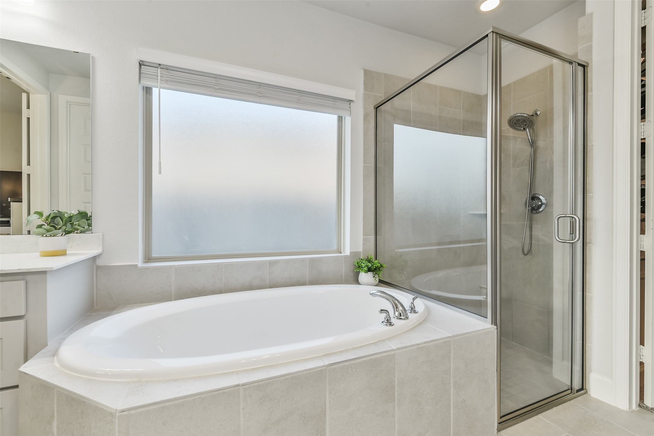 The soaking tub features a large frosted window above for natural light.