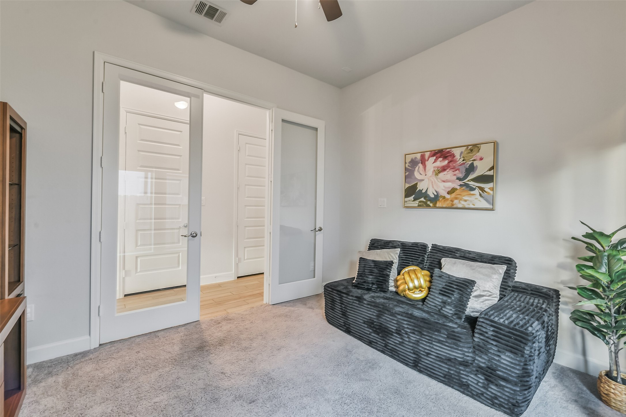 The study features a ceiling fan and gorgeous French doors and is wired for speakers.