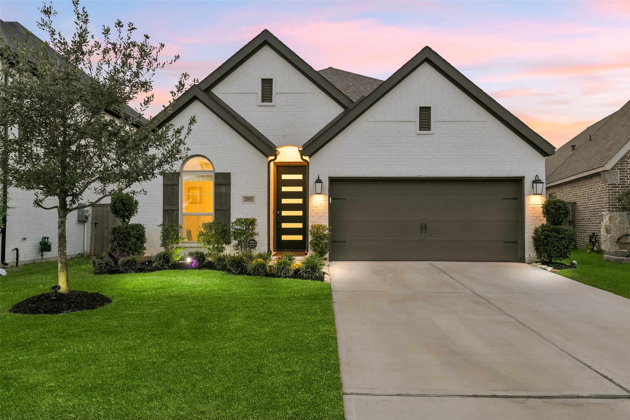 Mature landscaping in the front yard includes a beautiful full oak.