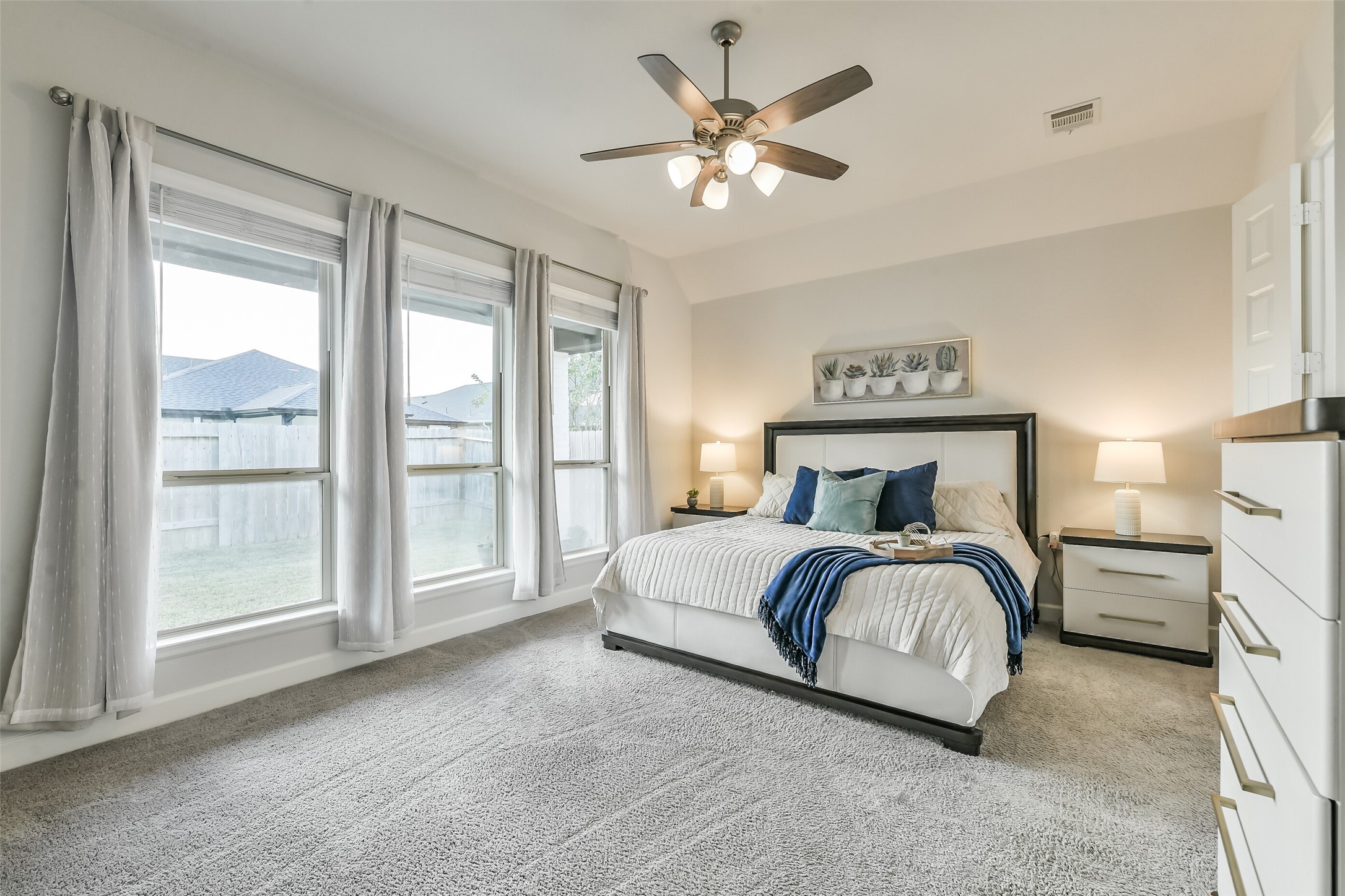 Directly off the living room is the gorgeous primary bedroom featuring a ceiling fan and several windows with full blinds for added privacy.