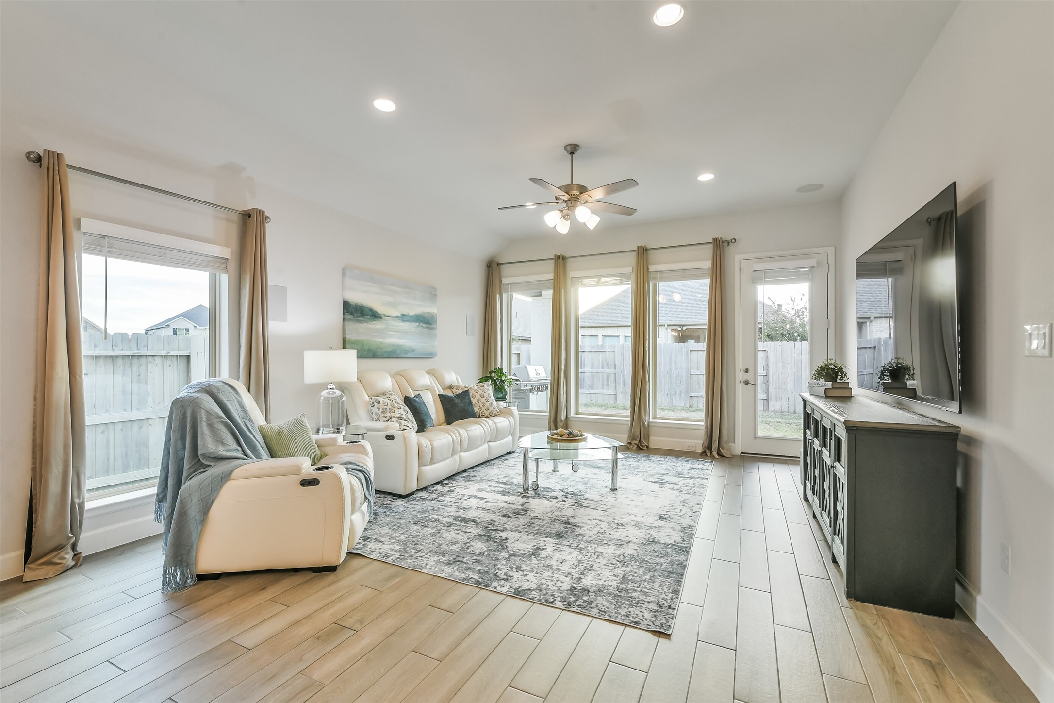 This beautiful living room features multiple windows providing plenty of natural light in the space and a built-in speaker system.
