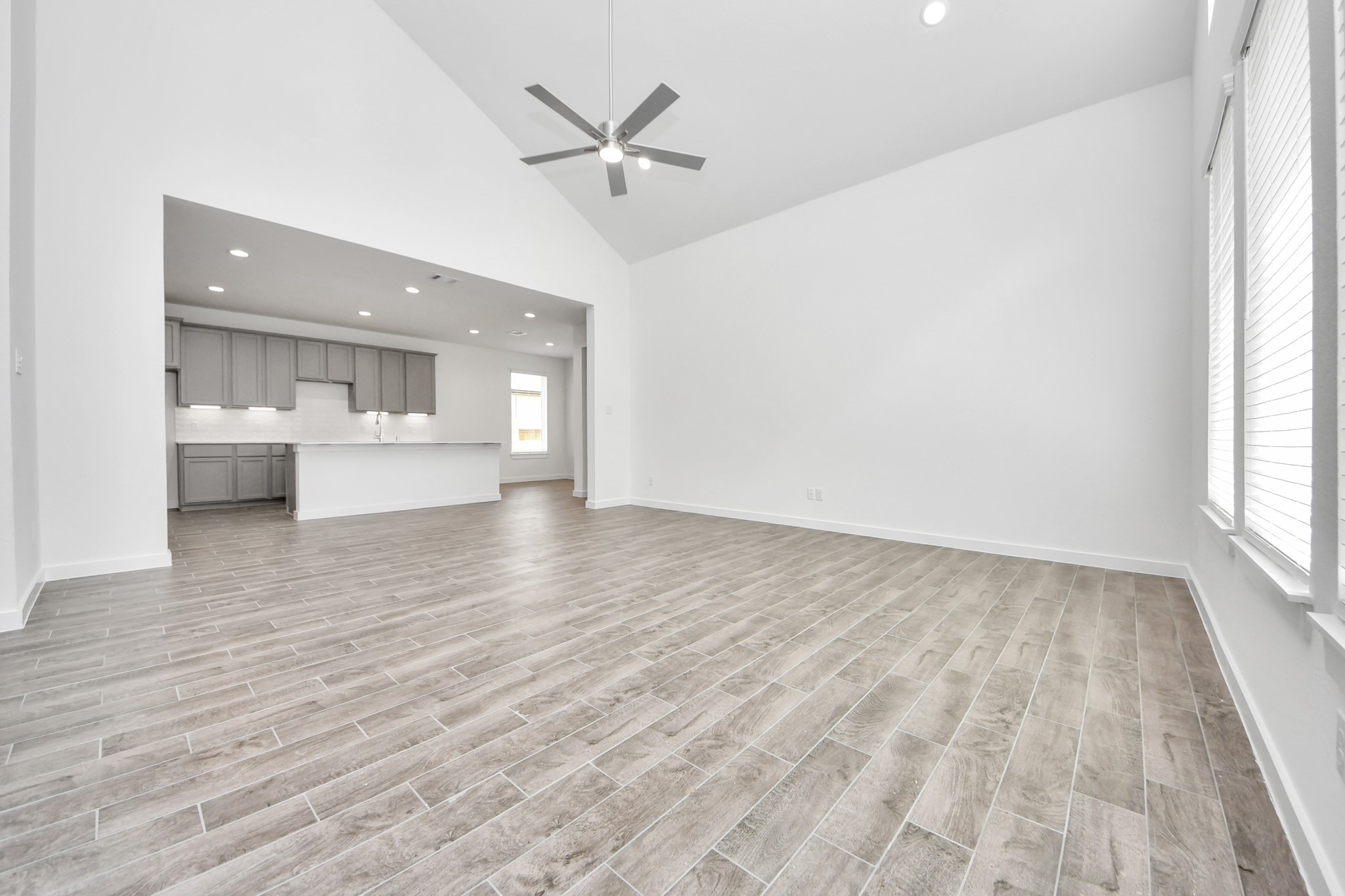 Gather the family and guests together in your lovely living room! Featuring soaring high ceilings, recessed lighting, ceiling fan, custom paint, gorgeous floors, and large windows that provide plenty of natural lighting throughout the day. Sample photo of completed home with similar floor plan. Actual colors and selections may vary.