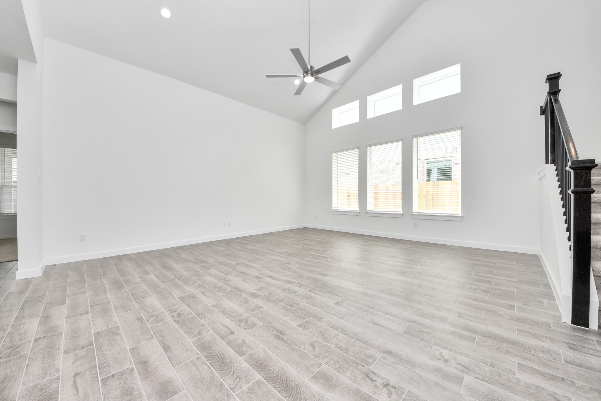 Welcome family and guests to your charming living room! With its high ceilings, recessed lighting, ceiling fan, custom paint, beautiful flooring, and large windows that let in abundant natural light, this room is perfect for gatherings. Sample photo of completed home with similar floor plan. Actual colors and selections may vary.