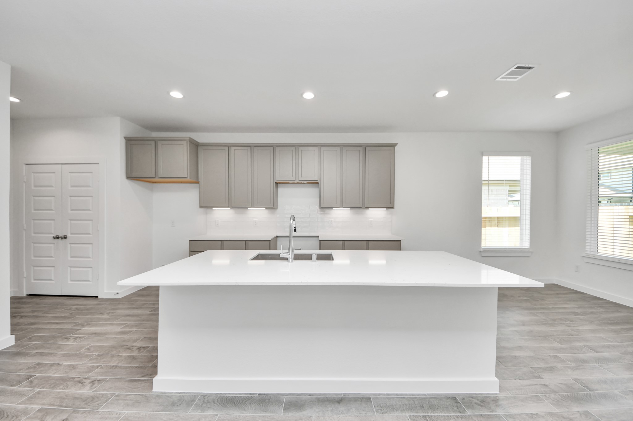 The kitchen is a culinary haven, featuring granite countertops, a tile backsplash, stainless steel appliances, 42 upper cabinets, and undercabinet lighting. Sample photo of completed home with similar floor plan. Actual colors and selections may vary.